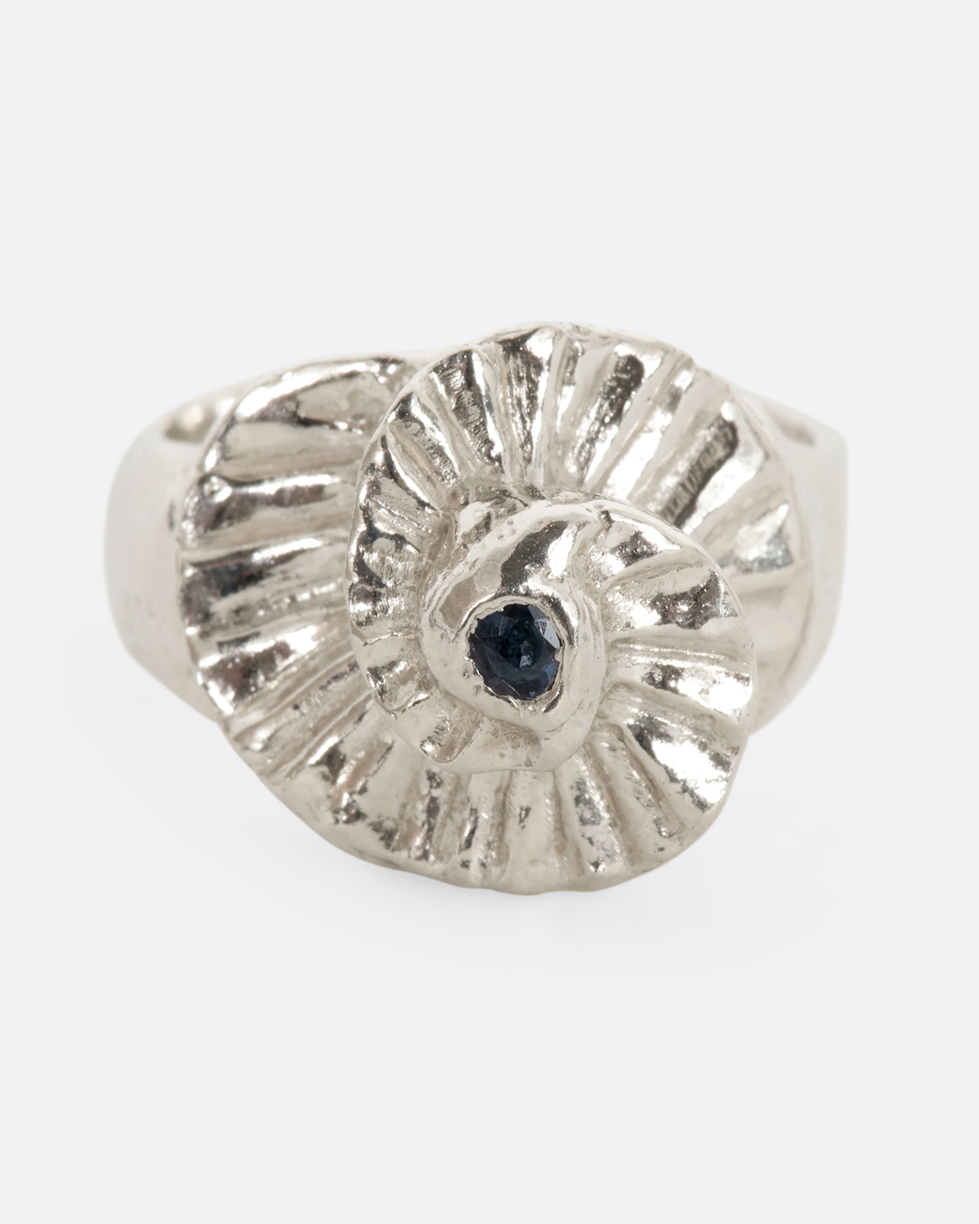 A sterling silver textured spiral ring with a single blue sapphire at the center. View from the front.