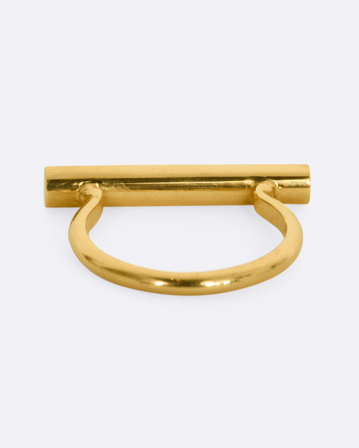 A polished yellow gold ring with a rectangular face that holds three channel set sliding diamonds. View from the back.