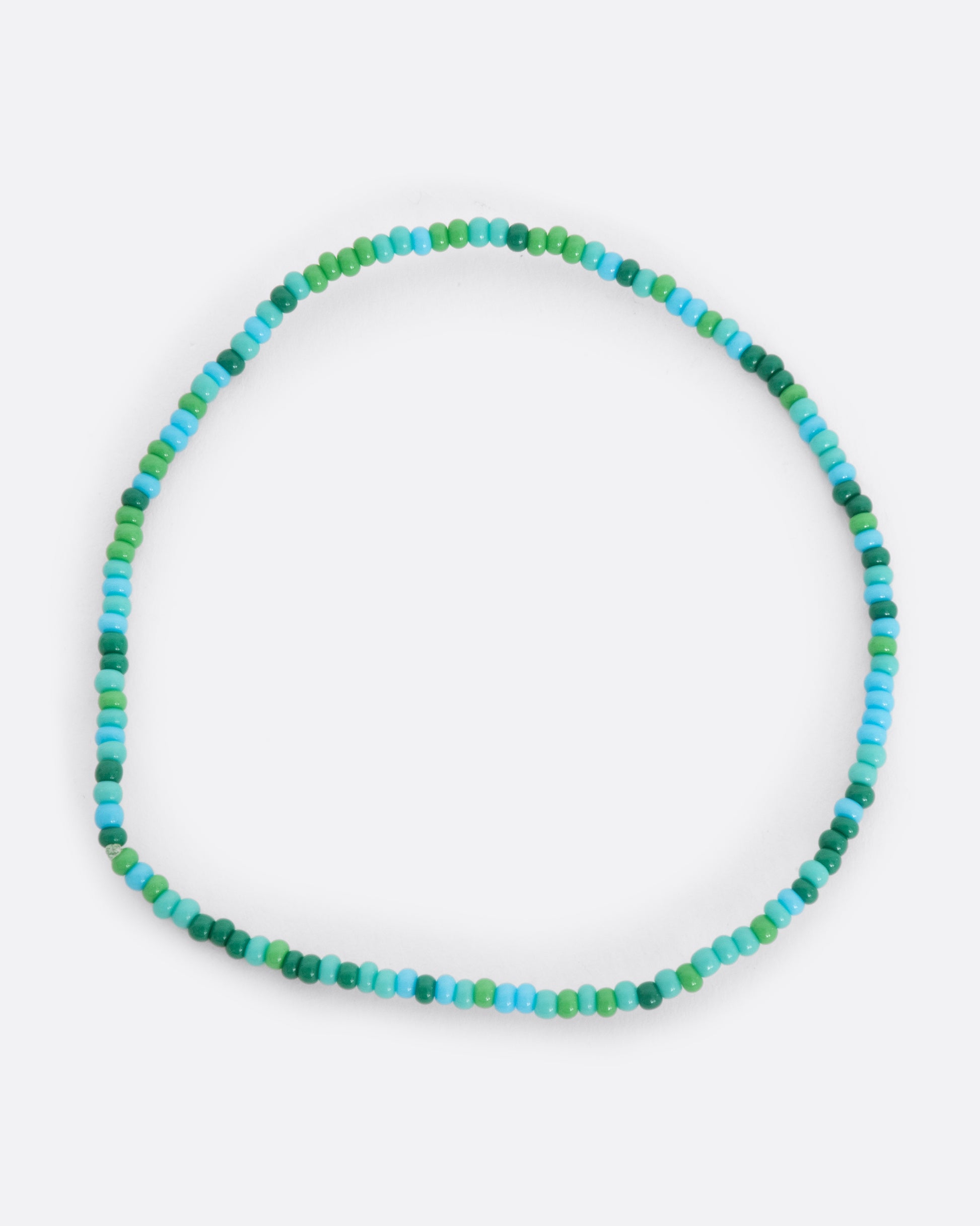 A stretchy bracelet with seed beads in blue and green.