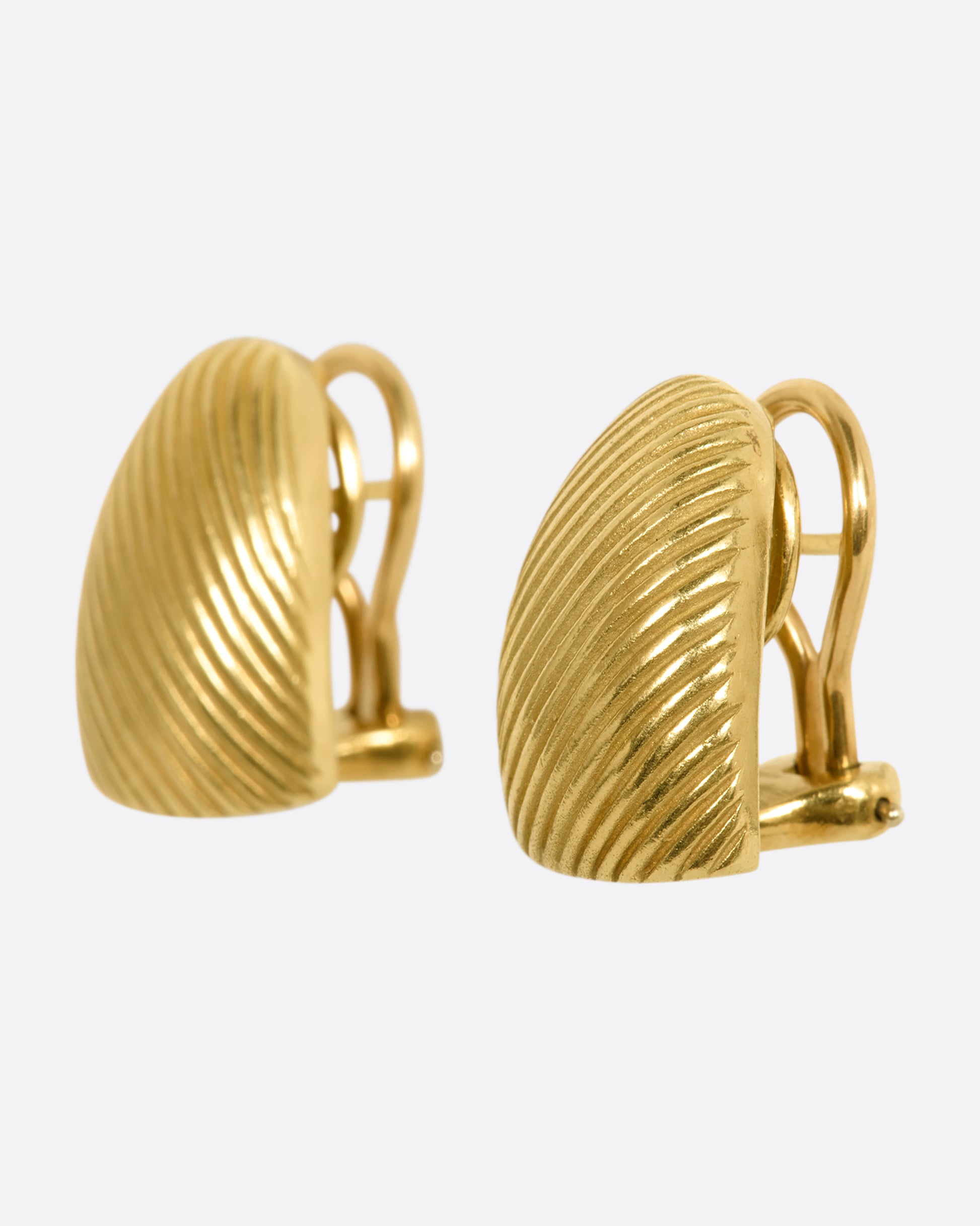 Yellow gold rounded earrings with diagonal striped. View from the side.