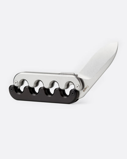 A stainless steel pocket knife with an interlocking mechanical hilt that moves with the blade and black handle, shown open from the side.