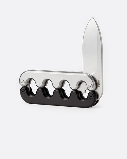 A stainless steel pocket knife with an interlocking mechanical hilt that moves with the blade and black handle, shown open from the side.