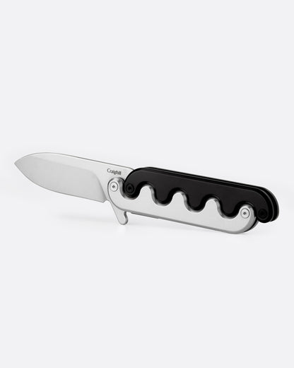 A stainless steel pocket knife with an interlocking mechanical hilt that moves with the blade and black handle, shown open from the side.