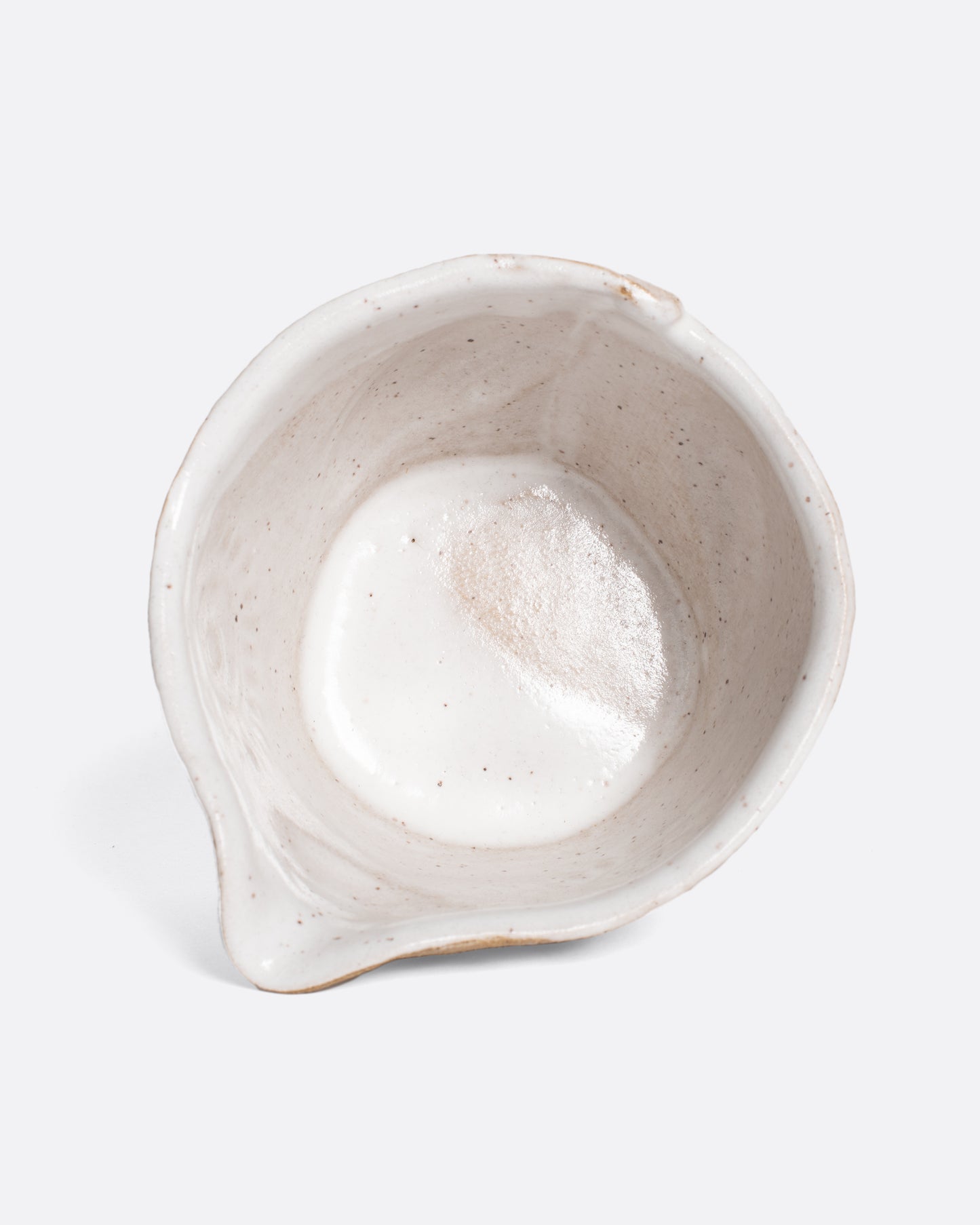 A handmade ceramic bird bowl whose beak serves as a spout, perfect for mixing and serving your favorite salad dressing.