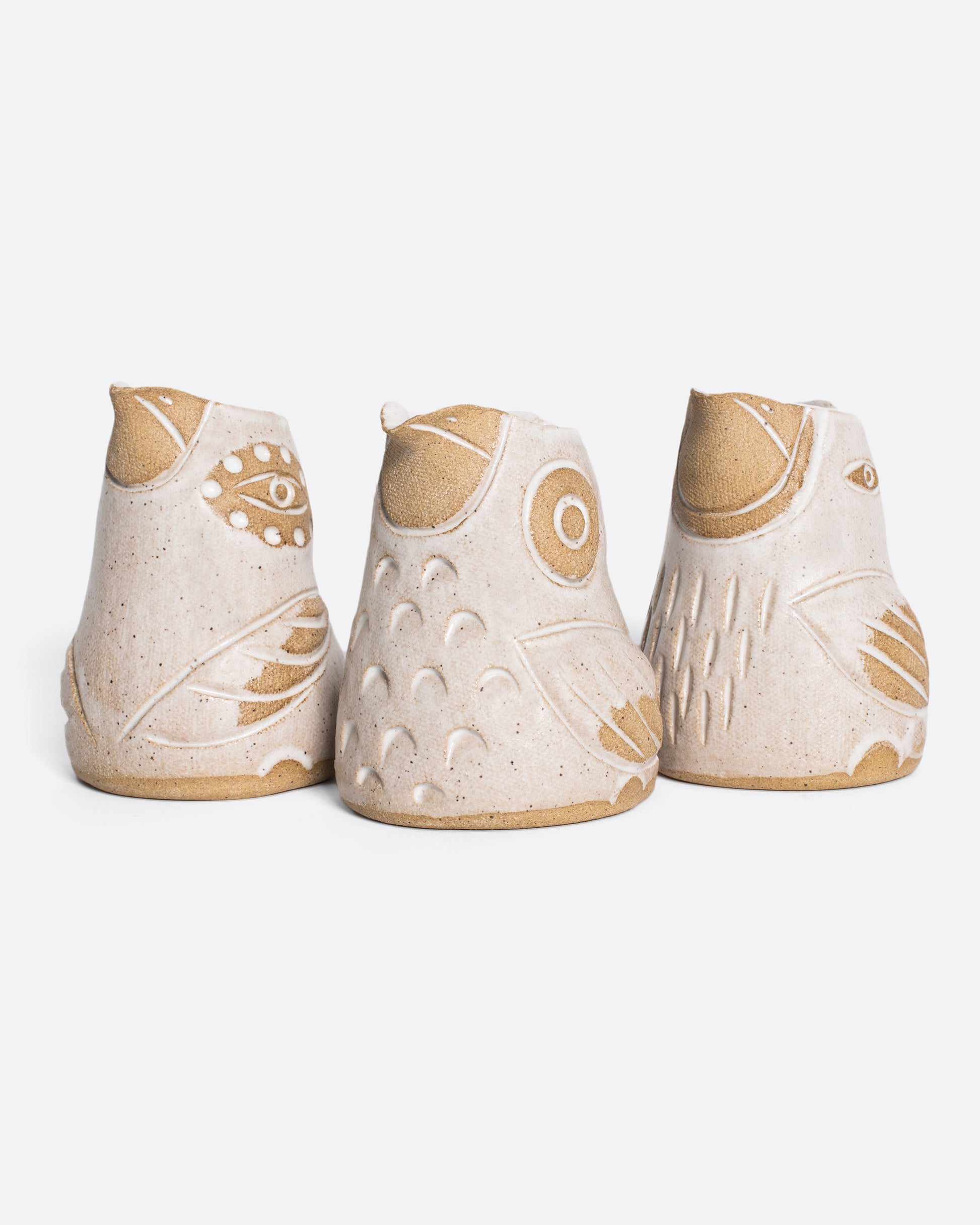 Group of three creamers shaped like birds in white and brown.