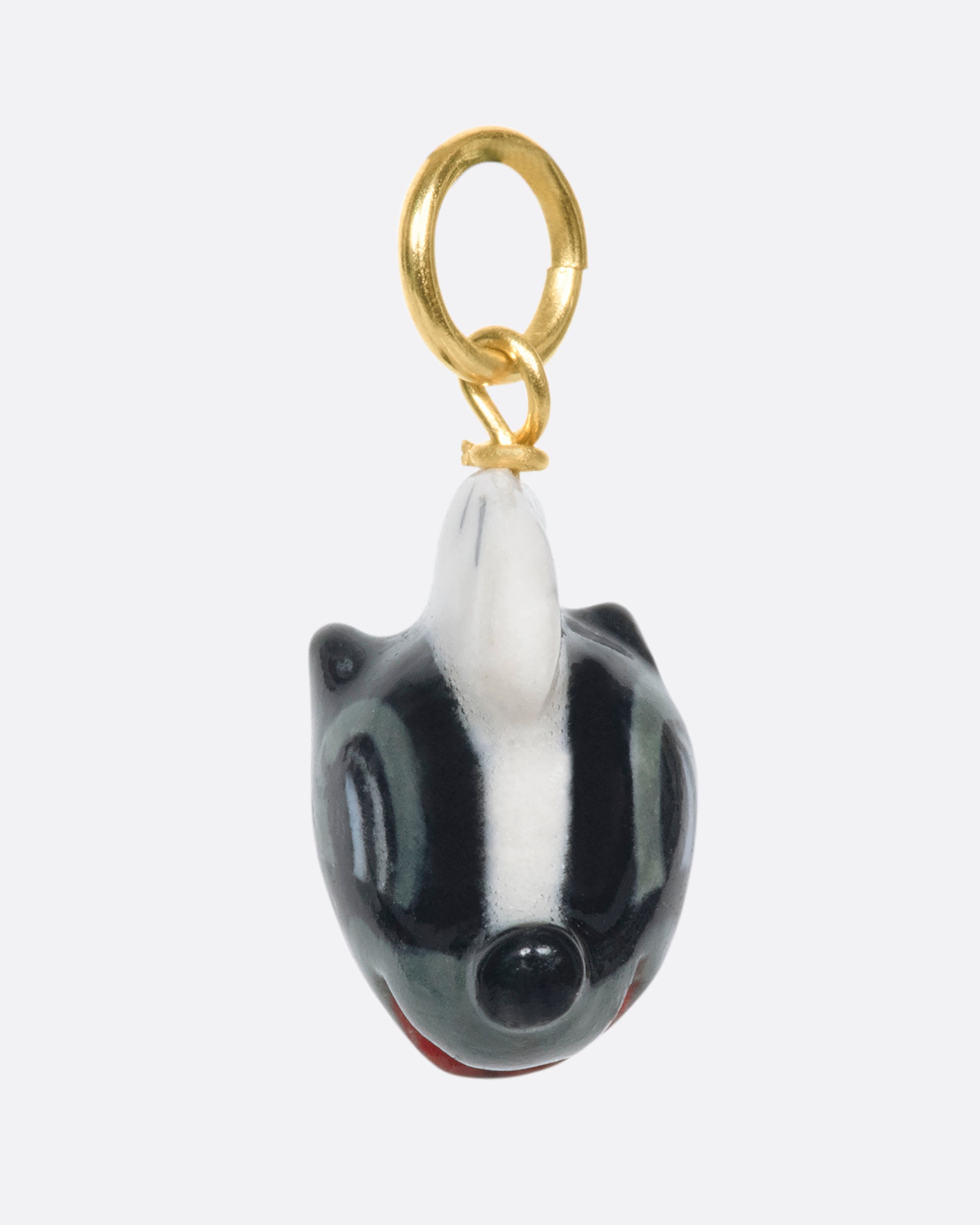 A handmade and painted porcelain Flower the Skunk charm with a 14k gold bail.