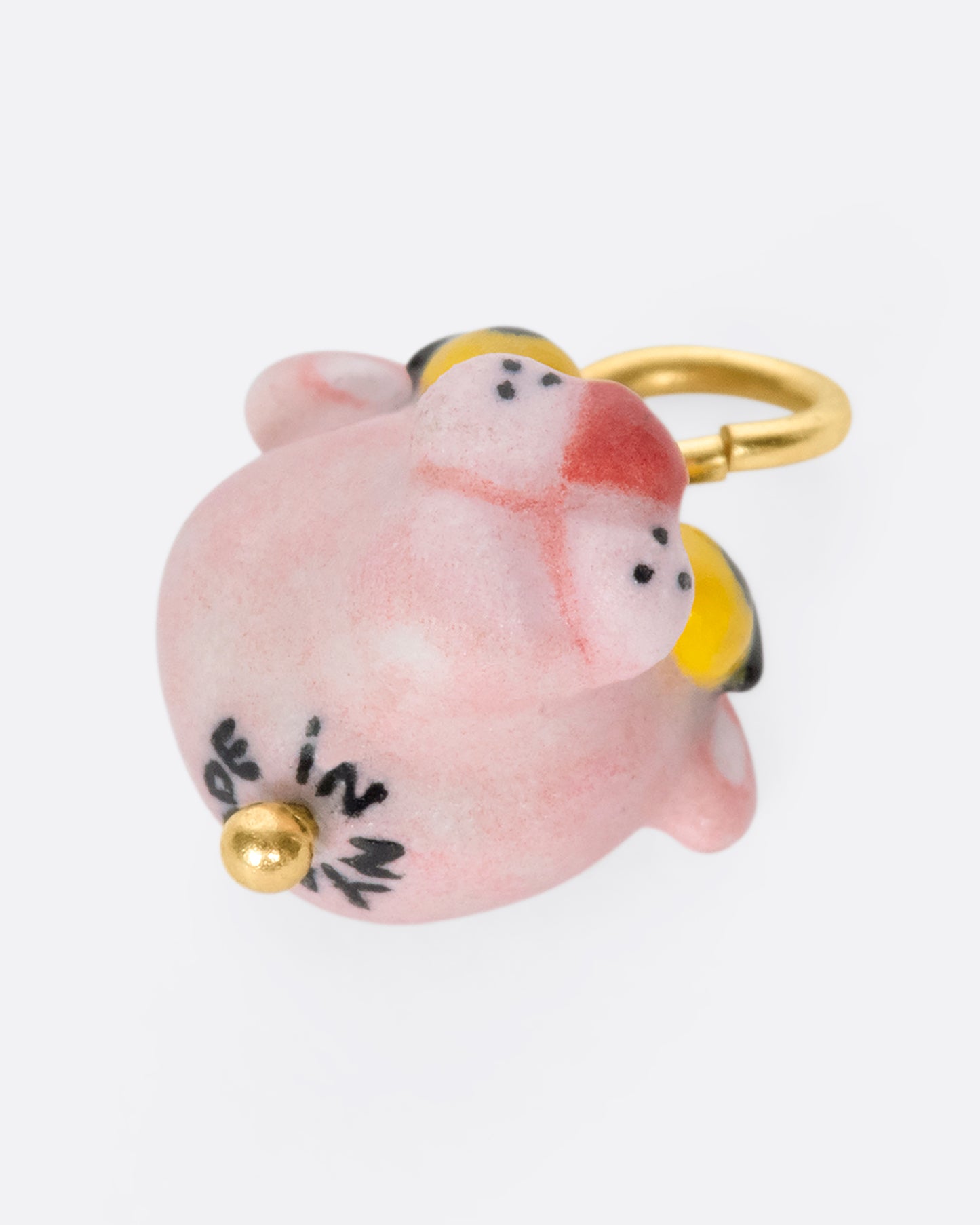 A handmade and painted porcelain Pink Panther charm with a 14k gold bail