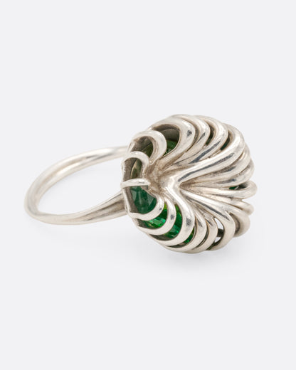 Sterling silver swirl cage ring with peridot, side view with the cage facing right