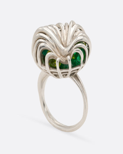 Sterling silver swirl cage ring with peridot, side view of the cage on a slim double band