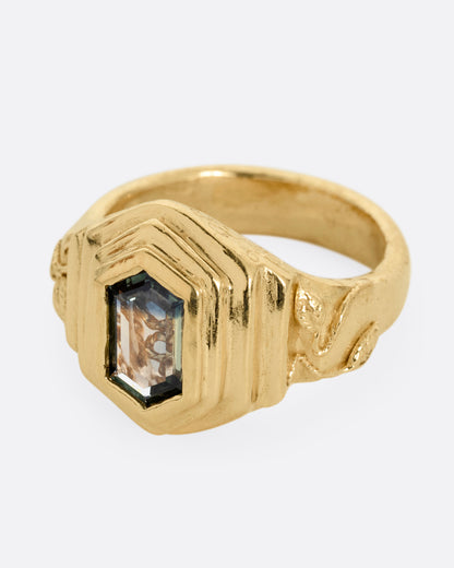 A yellow gold with a stepped center and a portrait cut bicolor tourmaline with a gold tendril that reveals itself through the stone. Shown from the side.