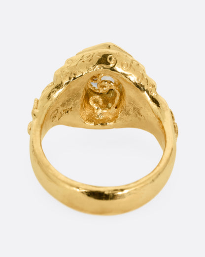 A yellow gold with a stepped center and a portrait cut bicolor tourmaline with a gold tendril that reveals itself through the stone. Shown from the back.