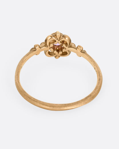 A yellow gold ring with a floral motif and pink tourmaline at the center. Shown from the back.