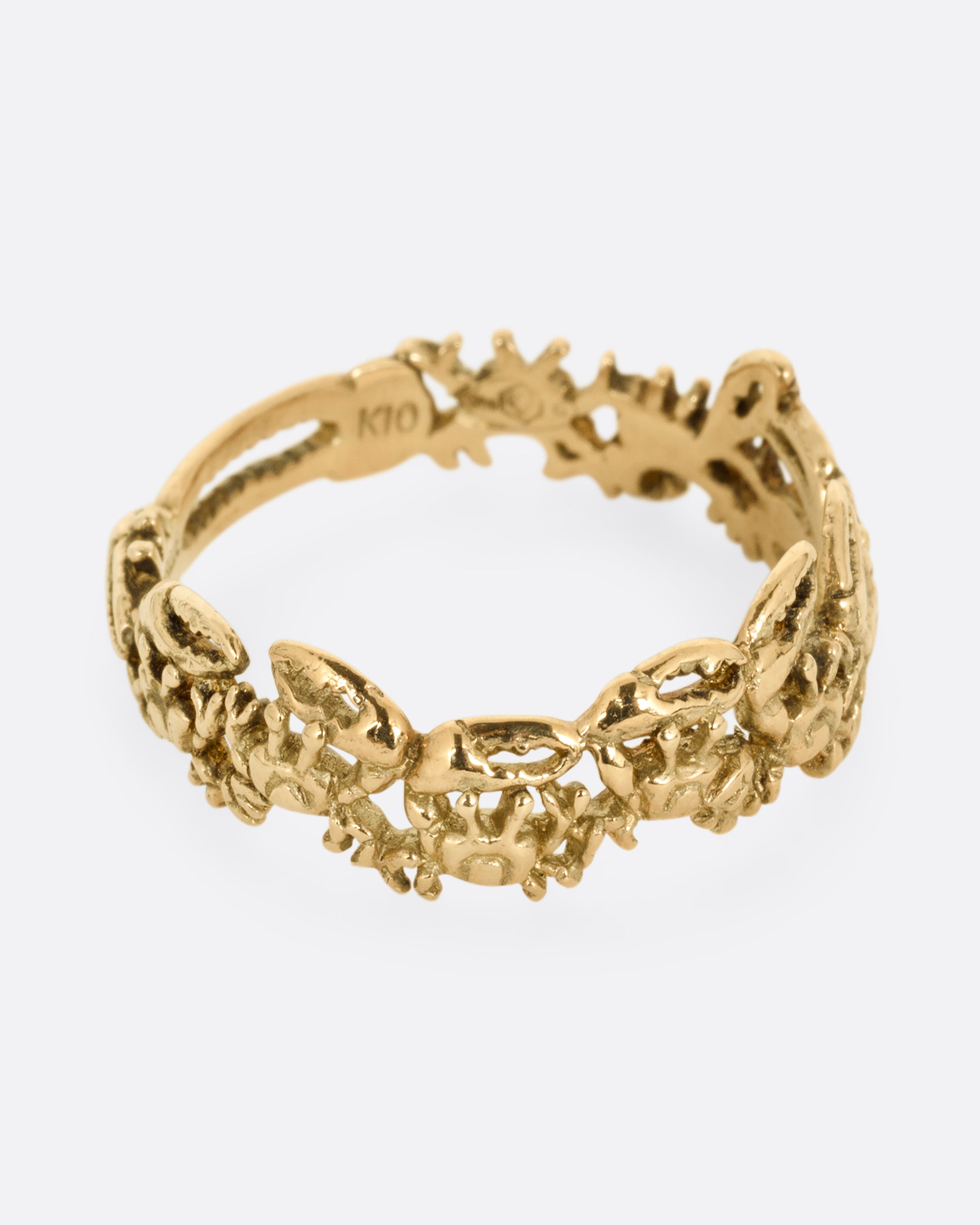A yellow gold ring with a queue of crabs. Shown from the side.