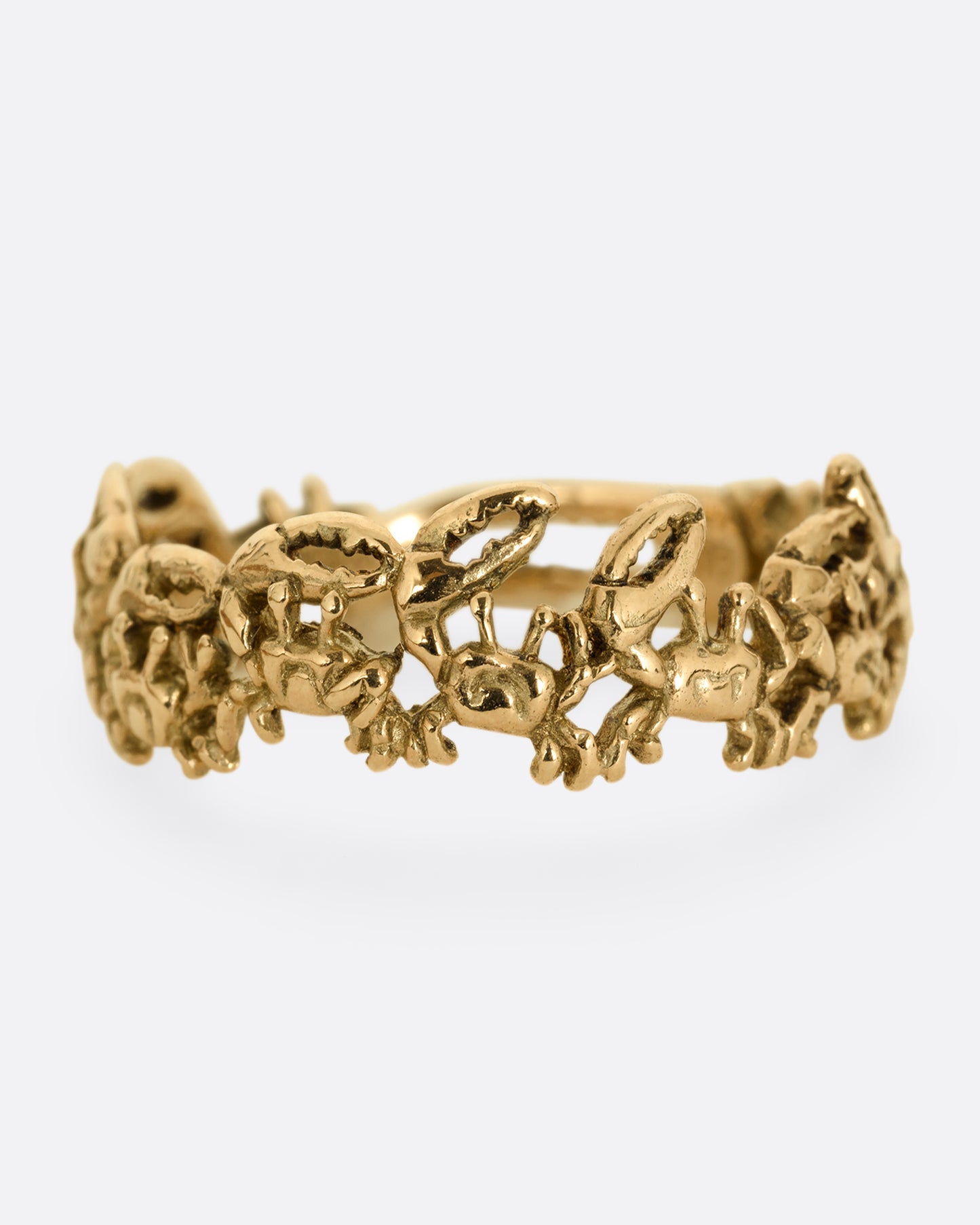 A yellow gold ring with a queue of crabs. Shown from the front.