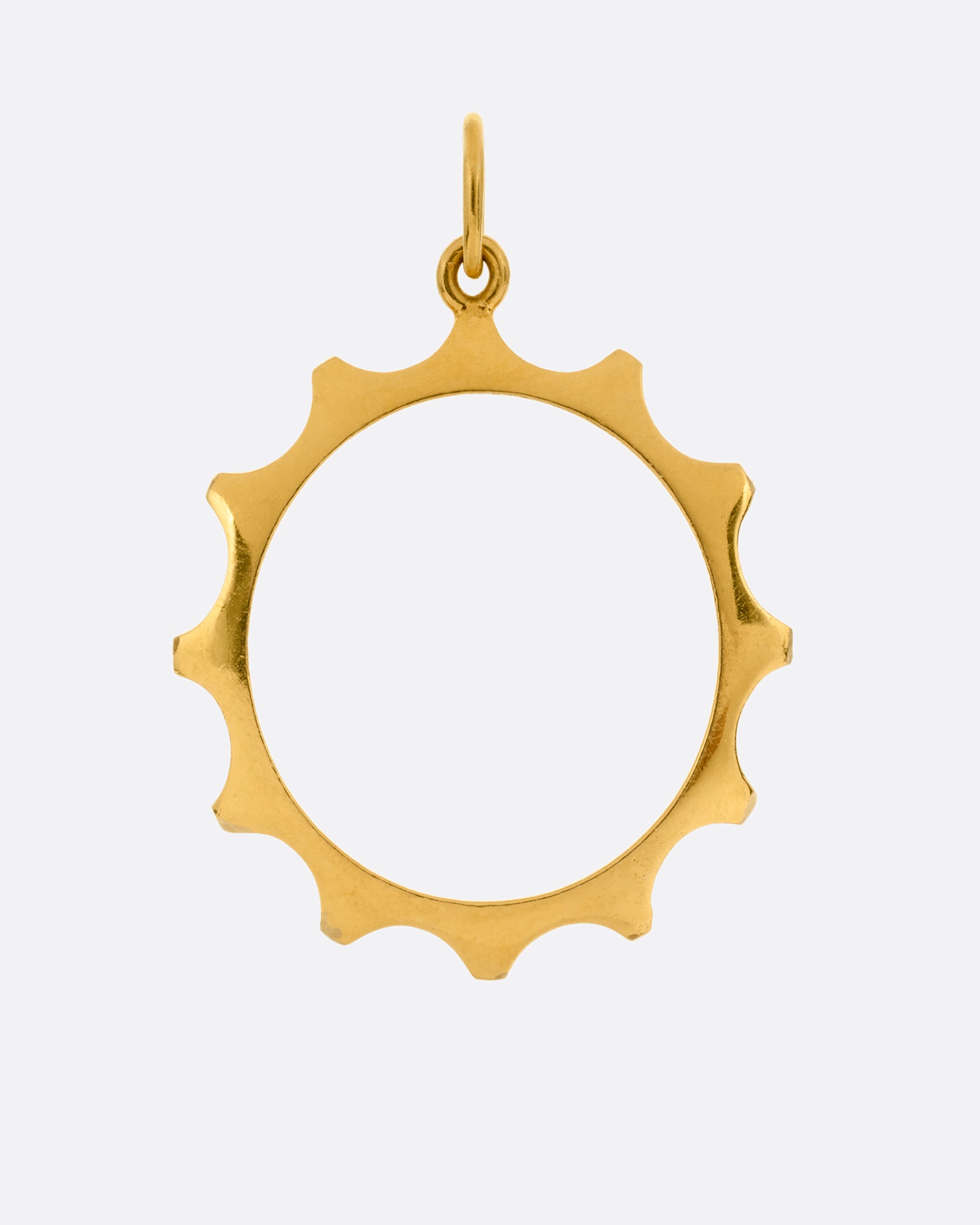 A yellow gold sun charm with an open center shown from the front.