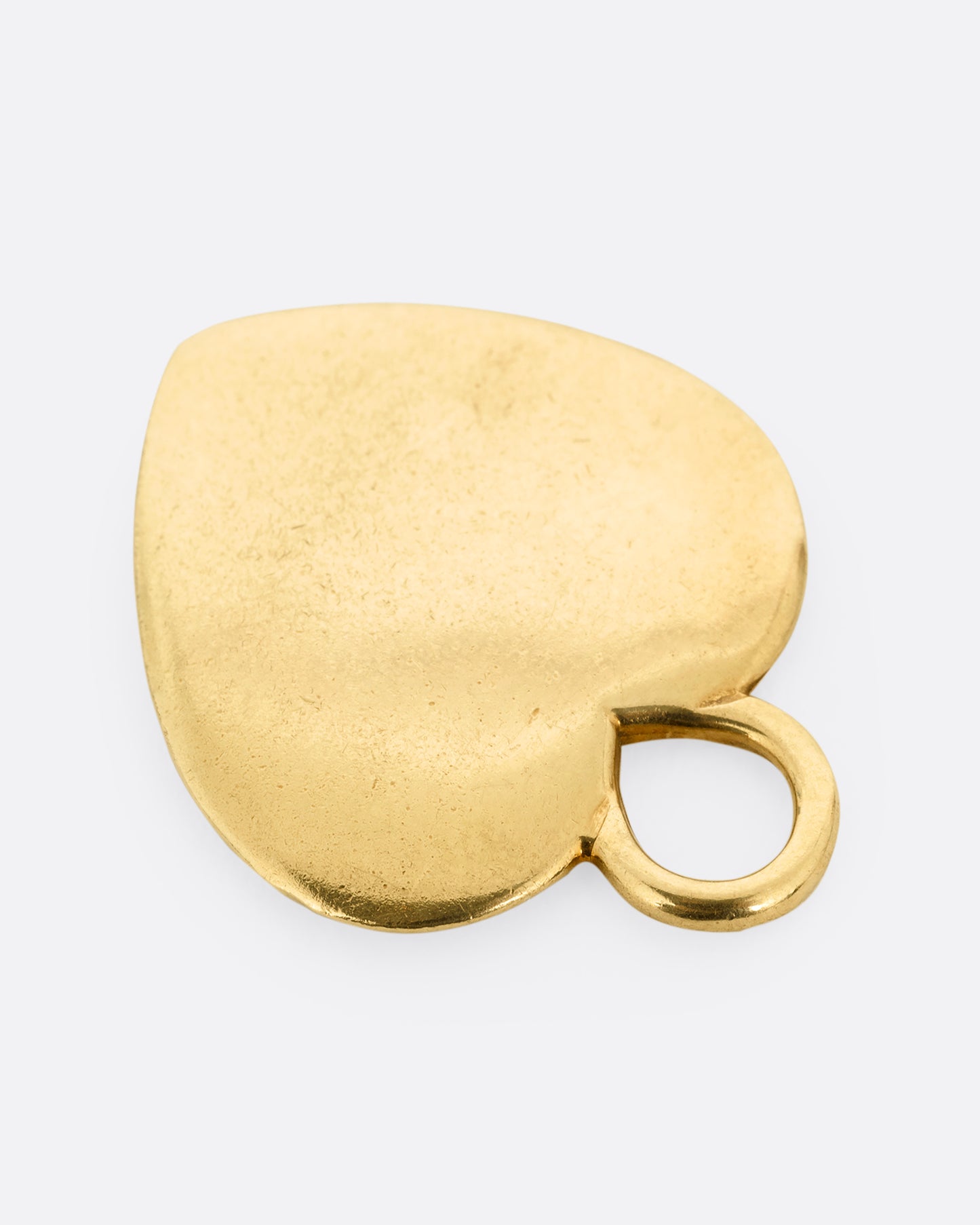 A yellow gold heart charm shown lying flat from the top.
