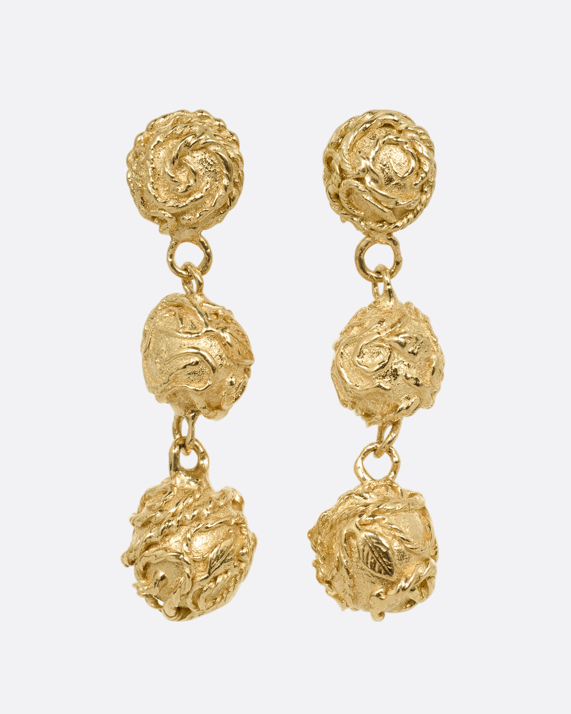 A pair of yellow gold dangle earrings with three linked spheres. Shown from the front.