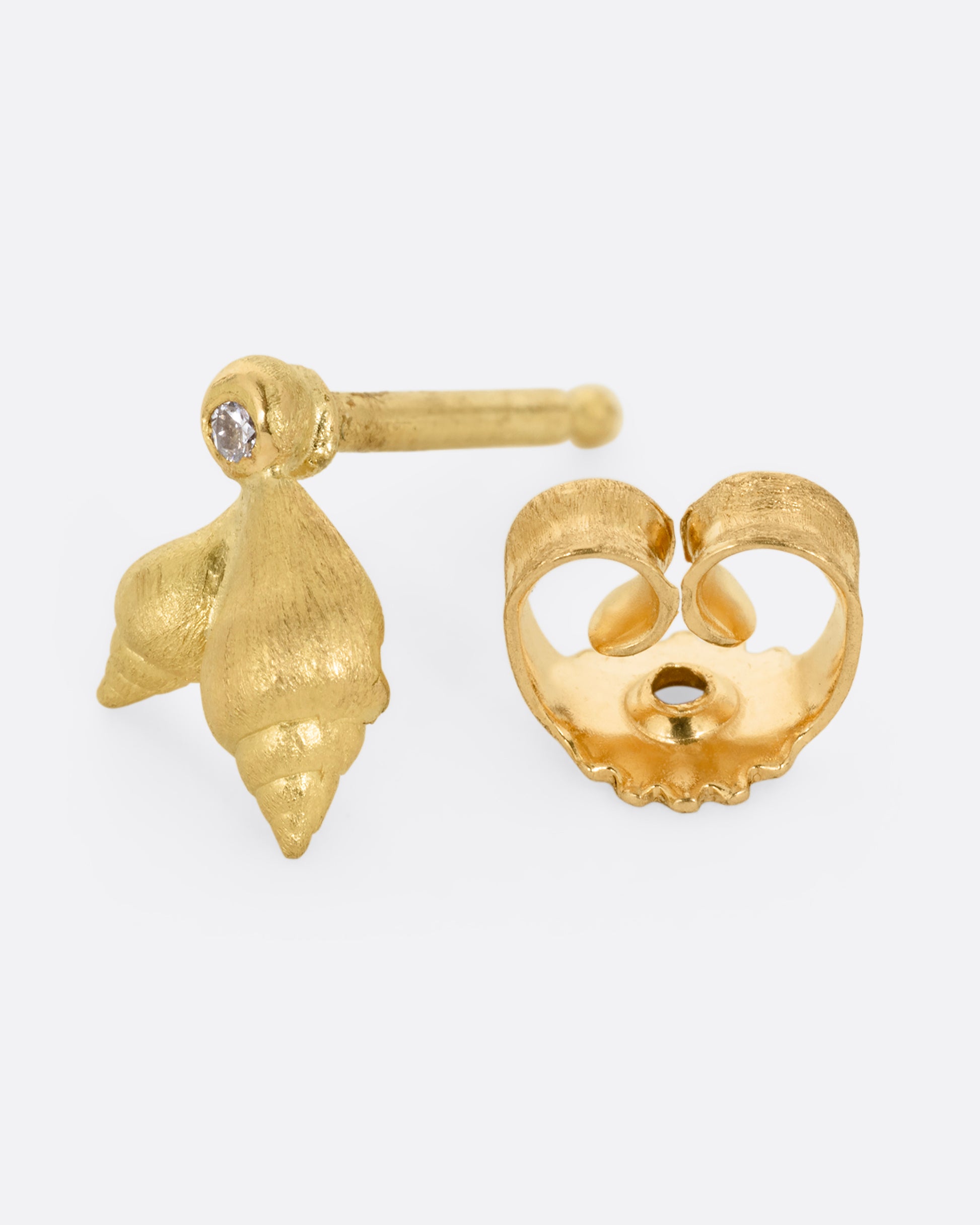 A yellow gold stud earring with two seashells and a diamond. Shown open from the side.