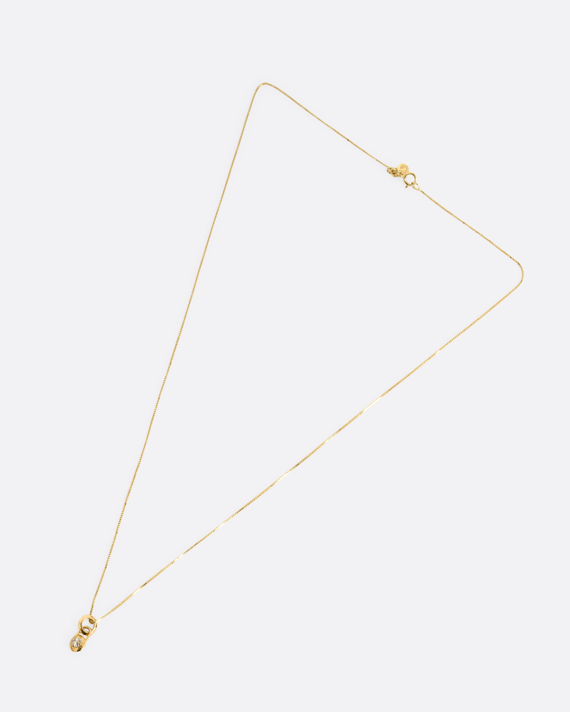 A yellow gold box chain with a padlock shaped pendant. A reverse set diamond is prong set in the center of the pendant. Shown from the front.