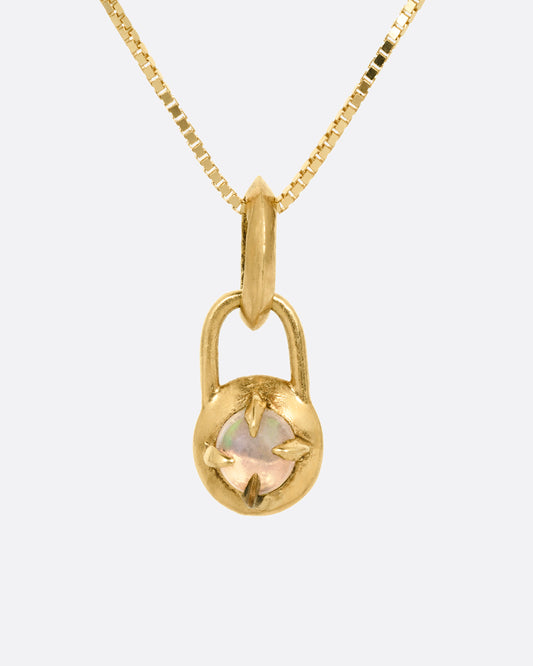 A yellow gold box chain necklace with a prong set opal cabochon pendant, shown from the front.