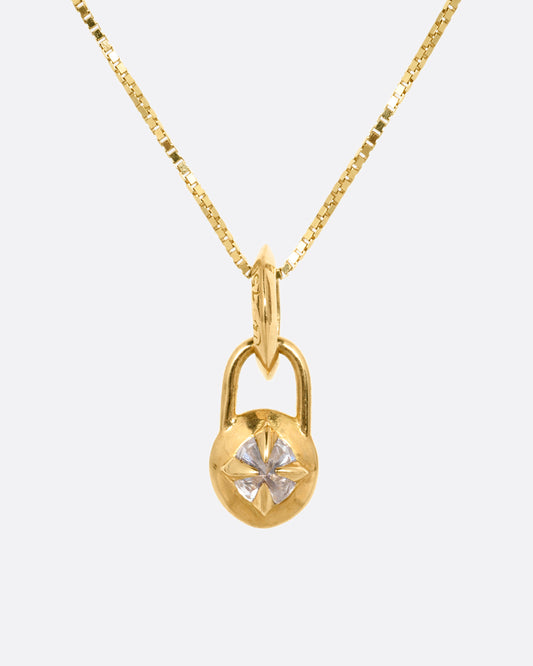 A yellow gold box chain with a padlock shaped pendant. A reverse set diamond is prong set in the center of the pendant. Shown from the front.