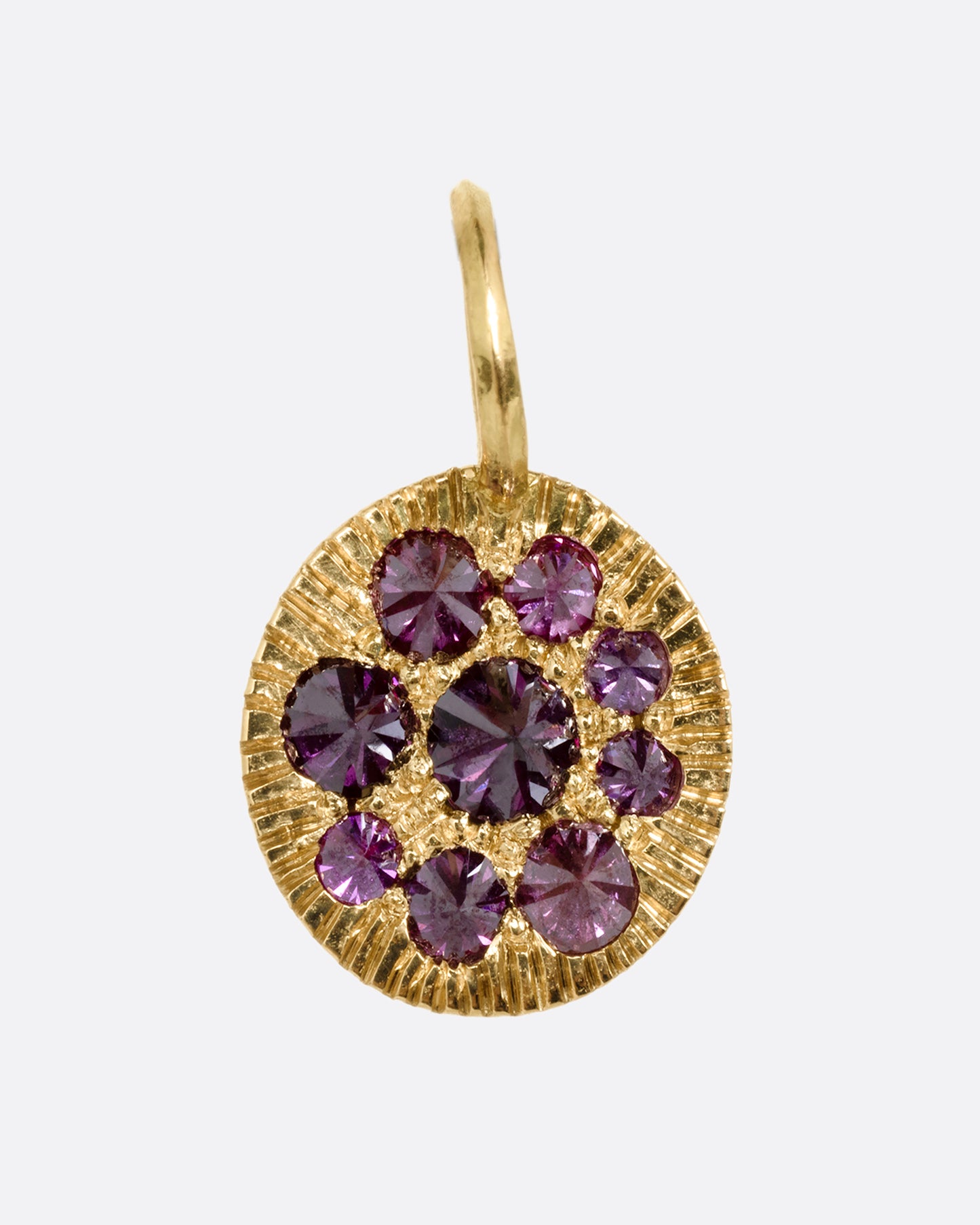 A yellow gold medallion with reverse set lavender diamonds, shown from the front.