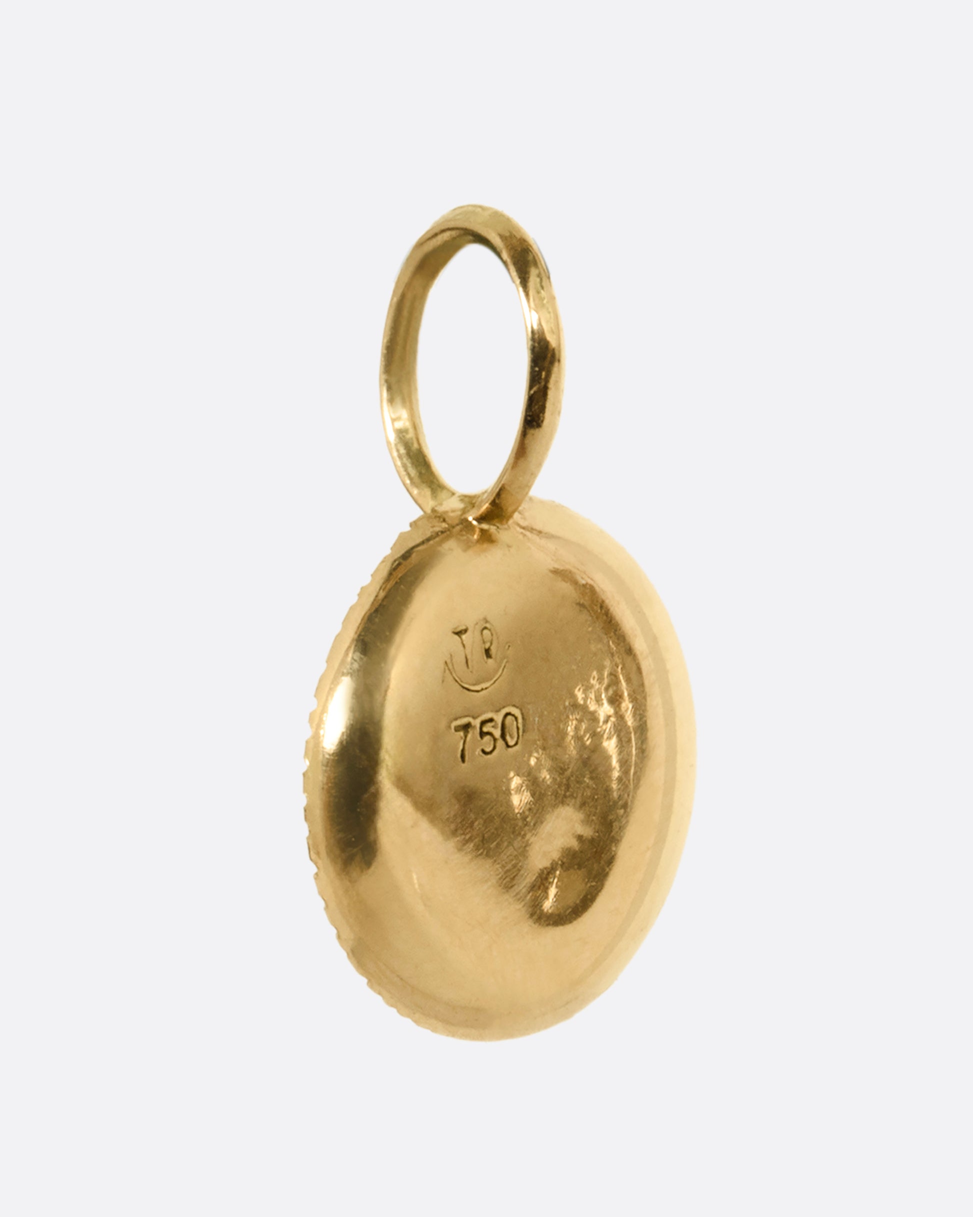 A yellow gold medallion with reverse set lavender diamonds, shown from the back.