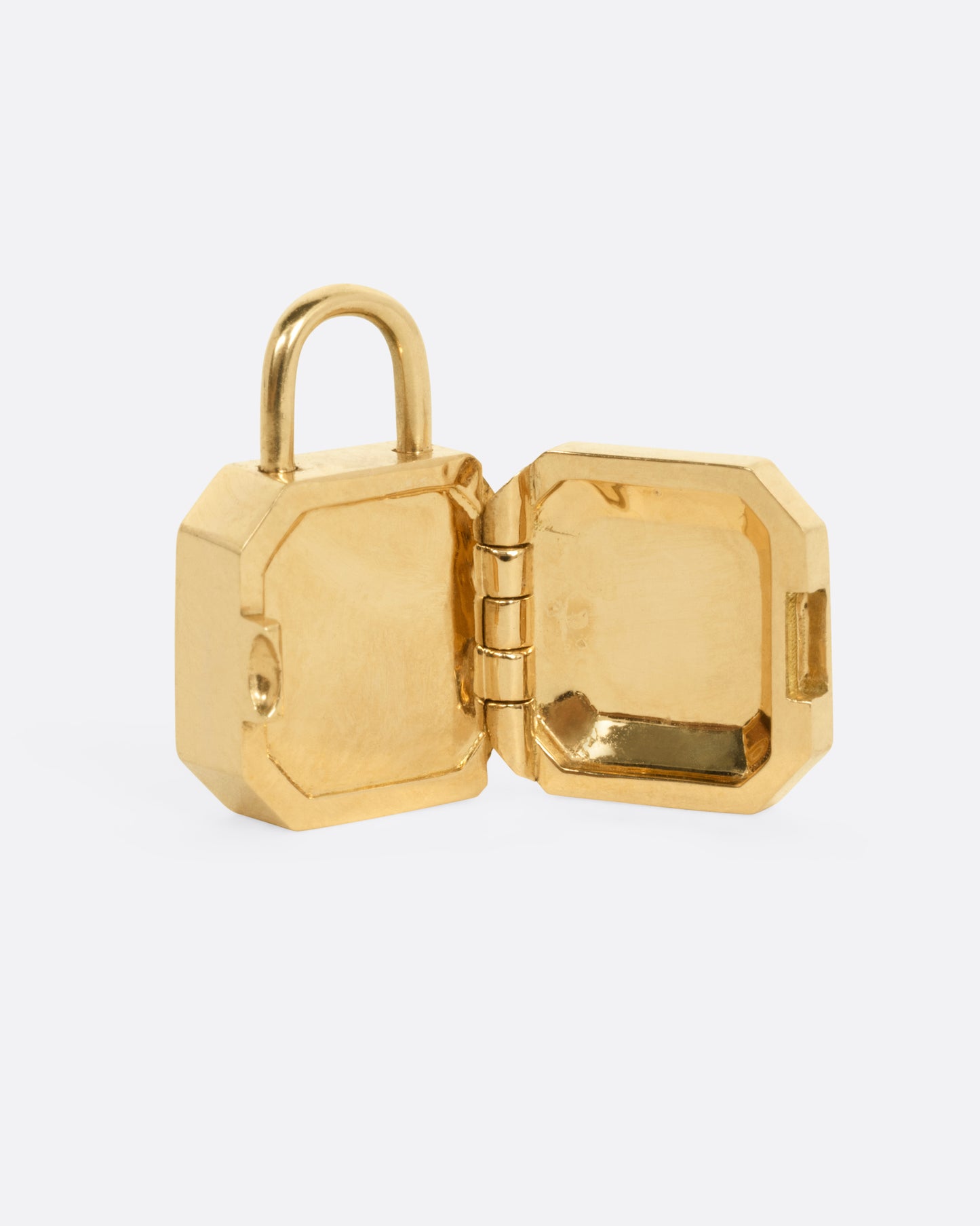 A yellow gold padlocket pendant featuring a large, faceted green emerald, shown open.
