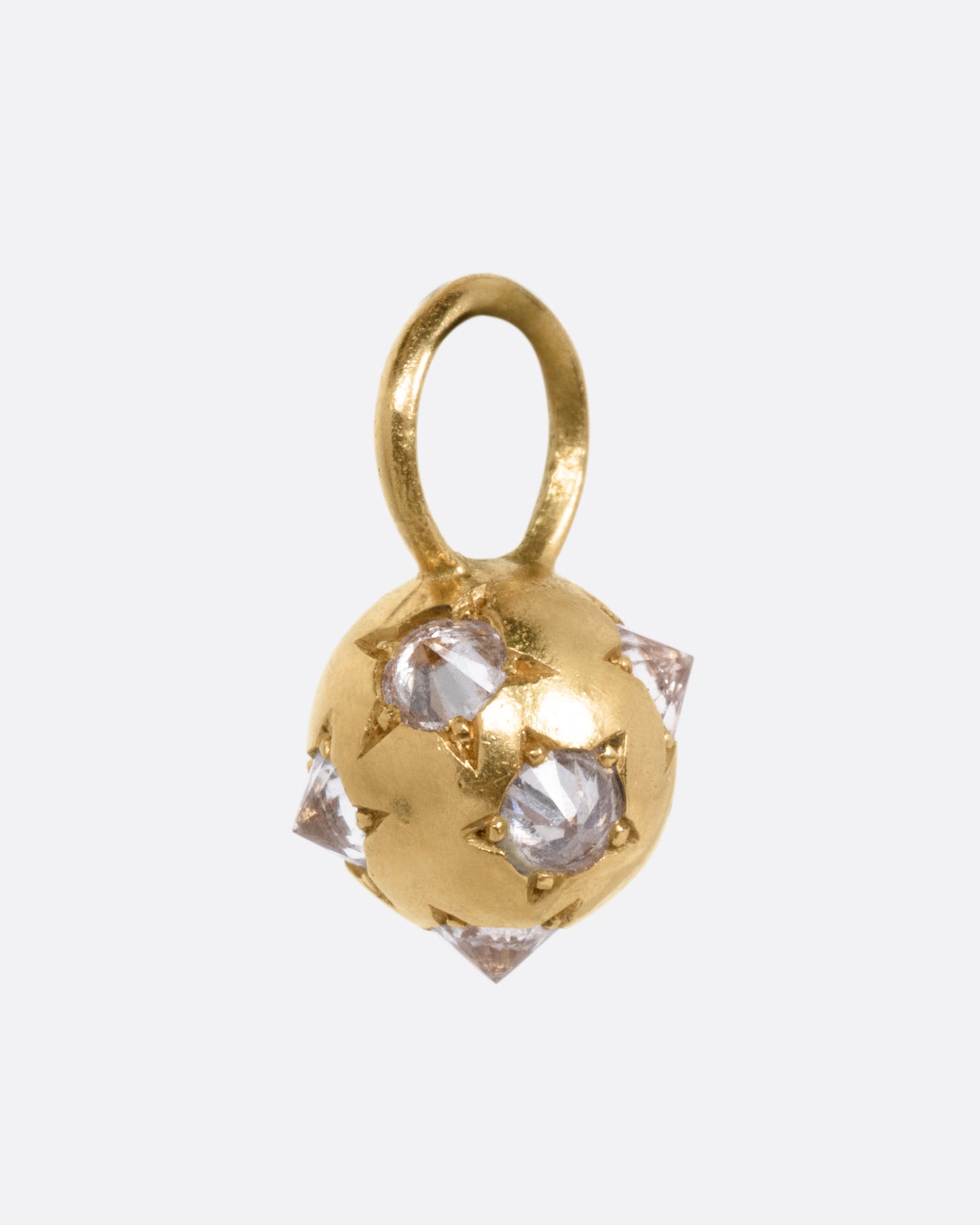 A yellow gold orb shaped charm with reverse set diamonds, shown from the side.