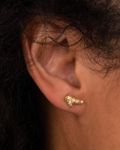 Kimberlin Brown coral stud earring in 18k yellow gold worn on an ear, a textured branch of gold coral set with small diamonds
