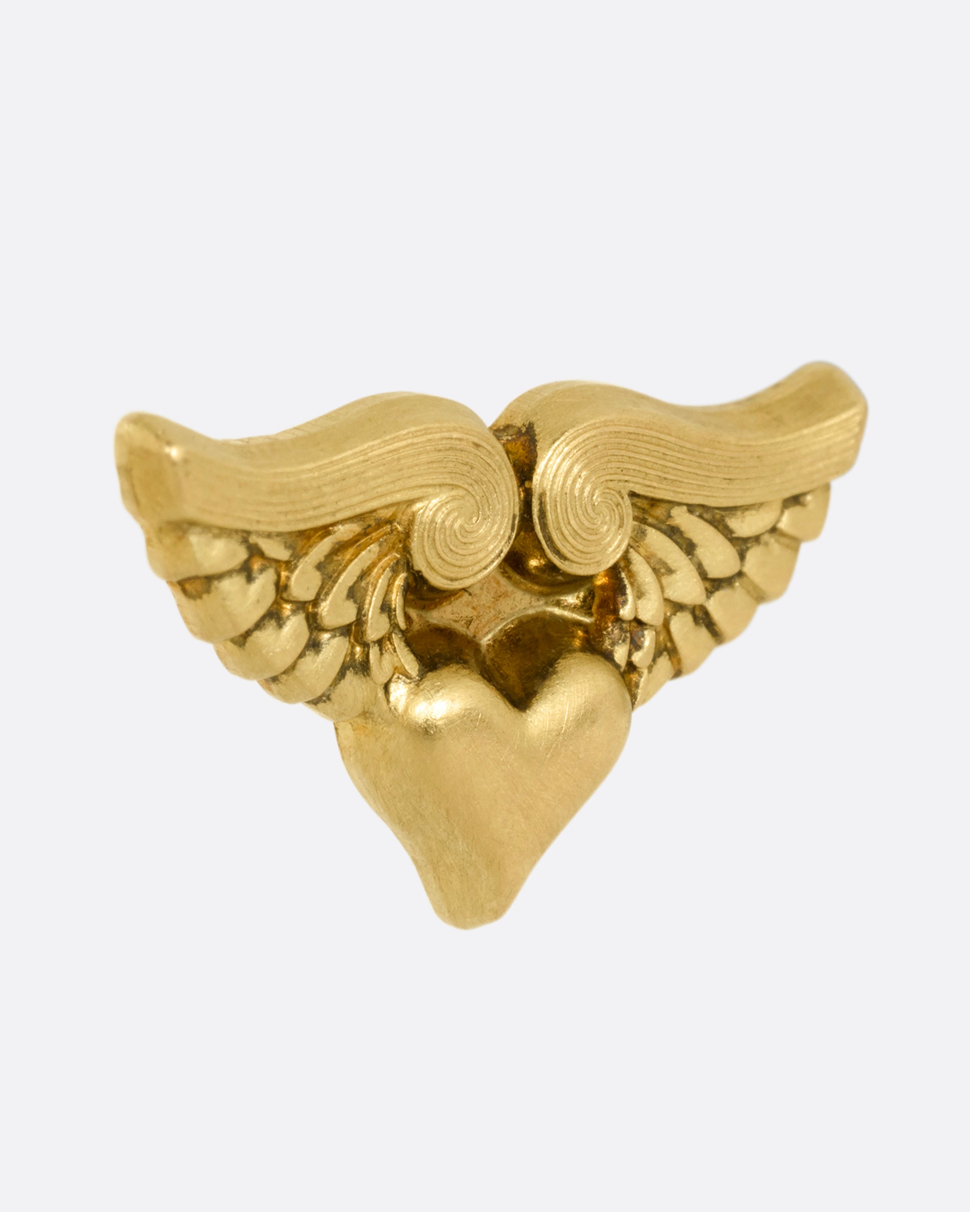 A yellow gold stud earring with a heart with wings. Shown from the side.