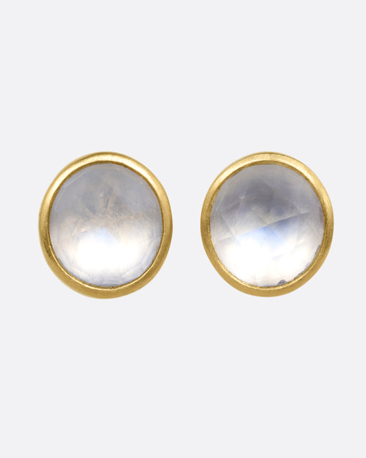 A pair of yellow gold stud earrings with moonstones. Shown from the front.