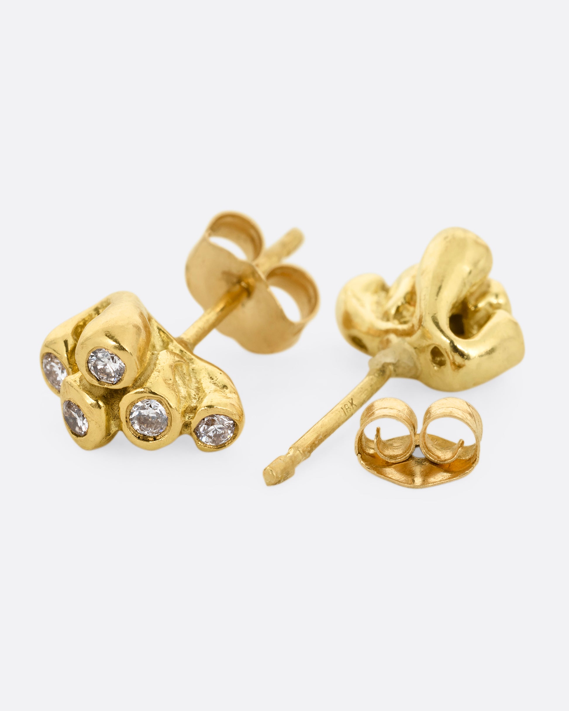 A pair of yellow gold earrings with sea anemone shaped clusters of diamonds. One earring is shown from the front, the other is open from the back.