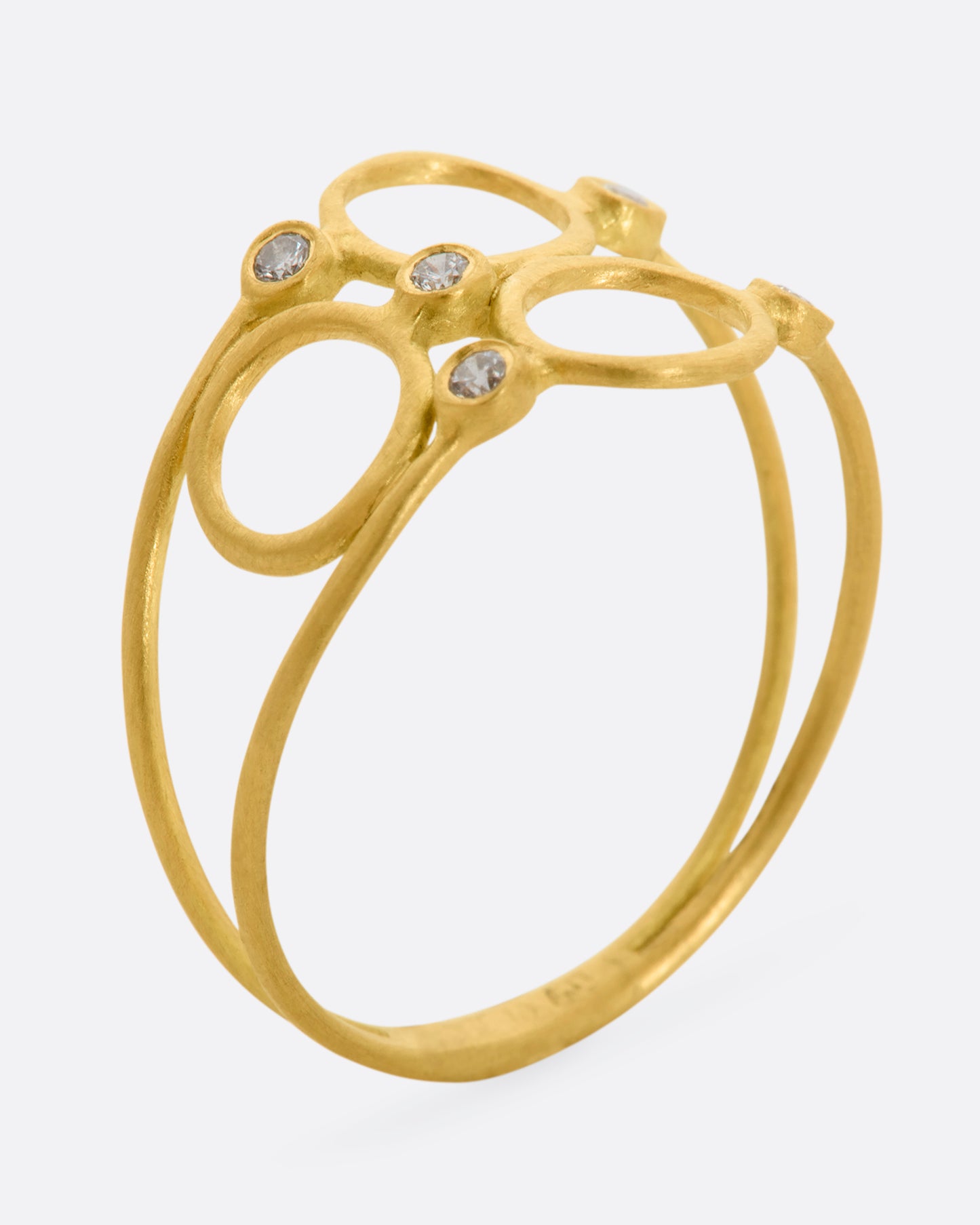 A yellow gold ring with three circles and five diamonds sandwiched between two thin bands. View standing up.