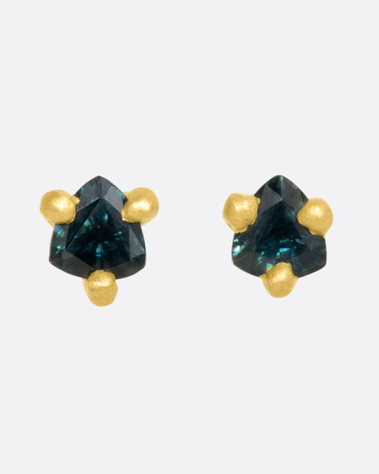 A pair of matte yellow gold prong set 4mm sapphire stud earrings. View from the front.