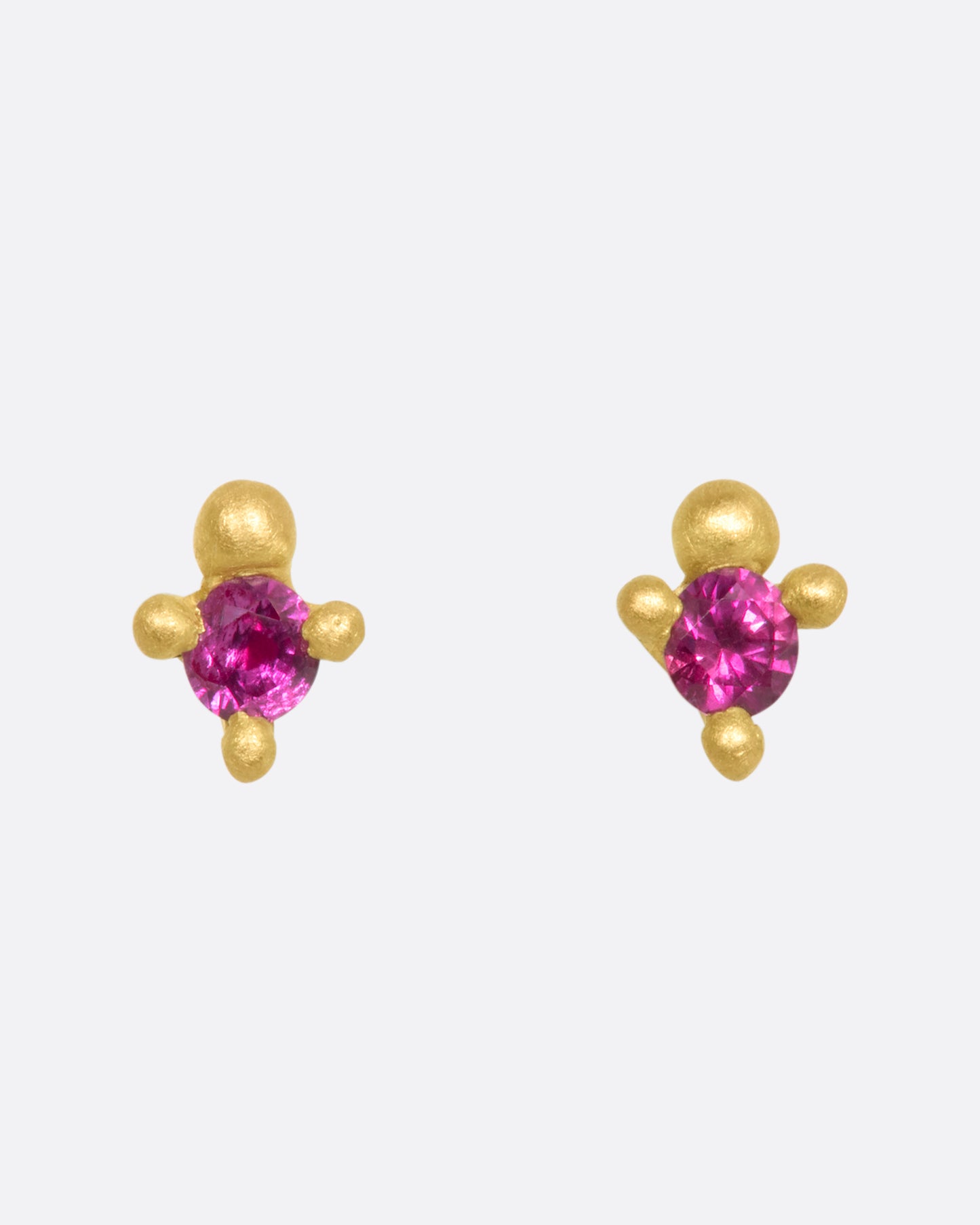 Yellow gold stud earrings with rubies. Shown from the front.