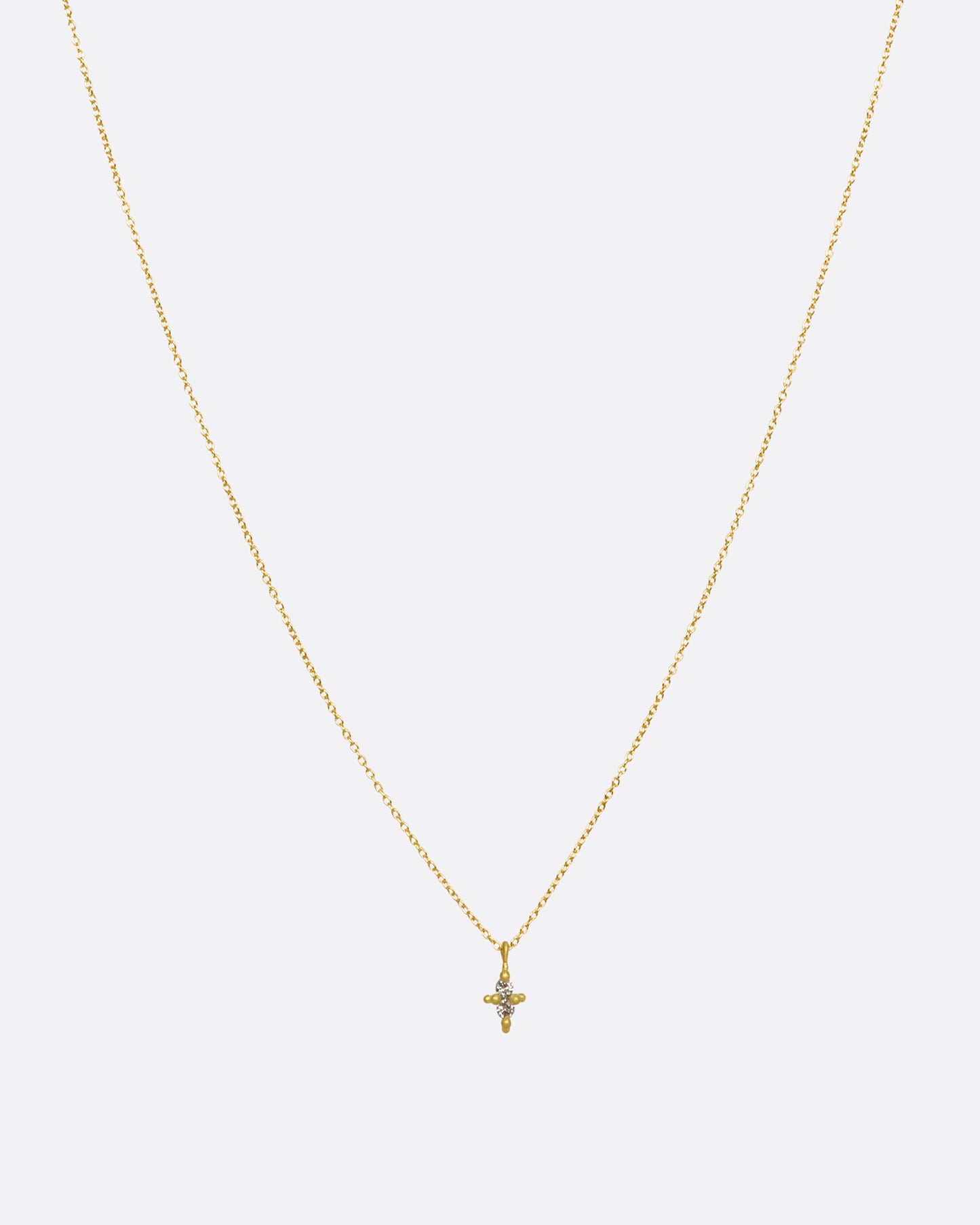 A yellow gold necklace with a double white diamond pendant. Shown from the front.