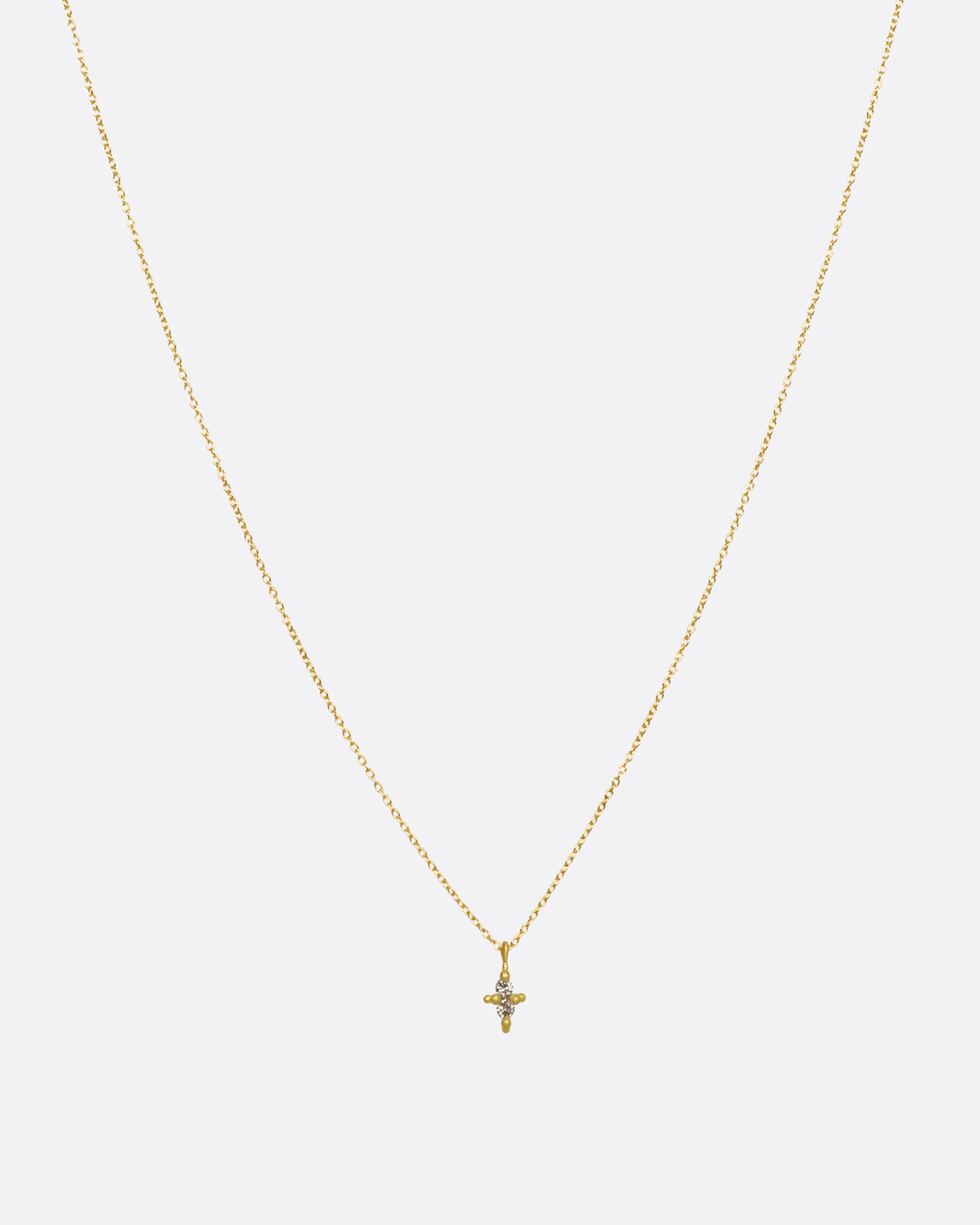 A yellow gold necklace with a double white diamond pendant. Shown from the front.