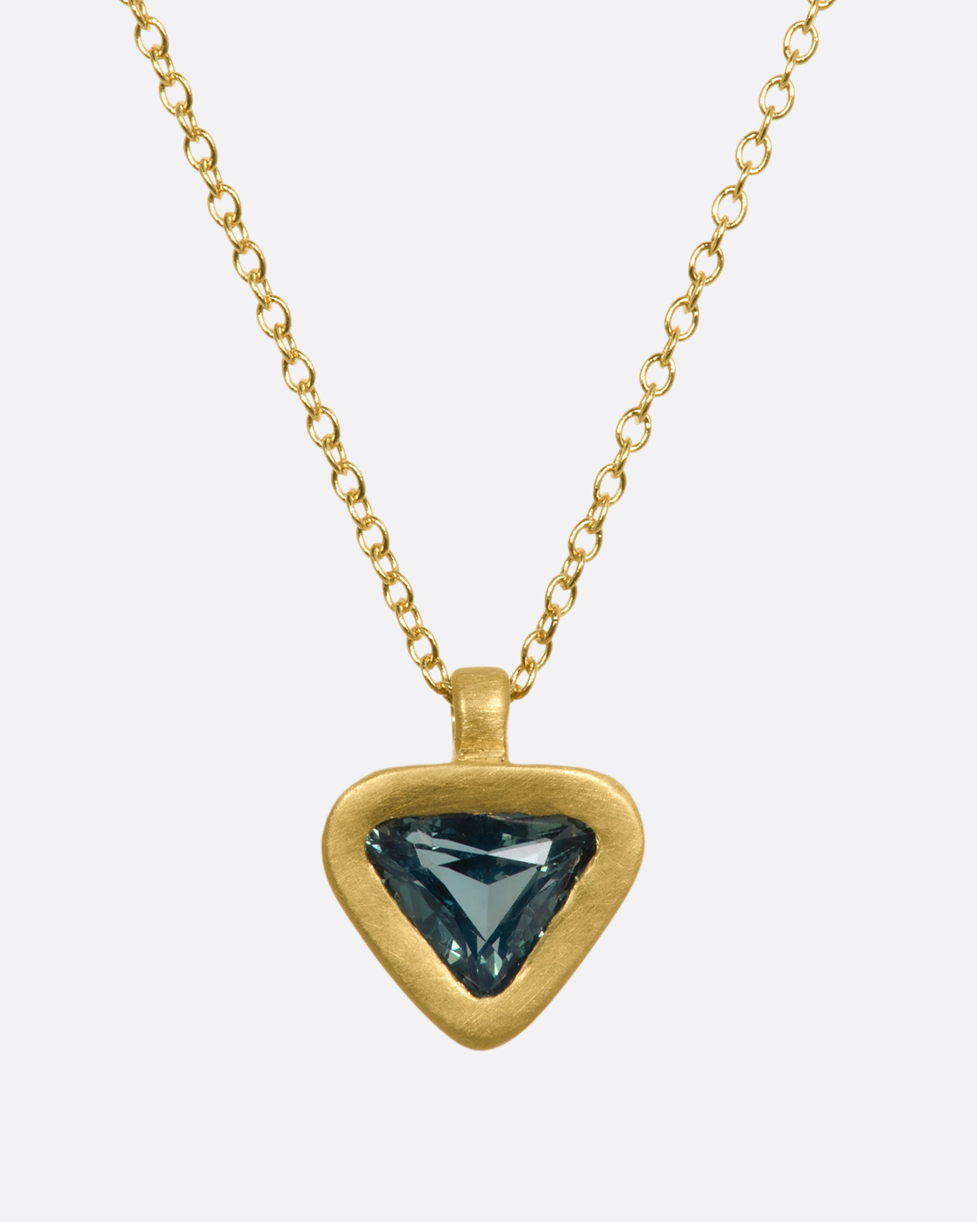 A yellow gold pendant with a triangle green sapphire pendant. View from the front.