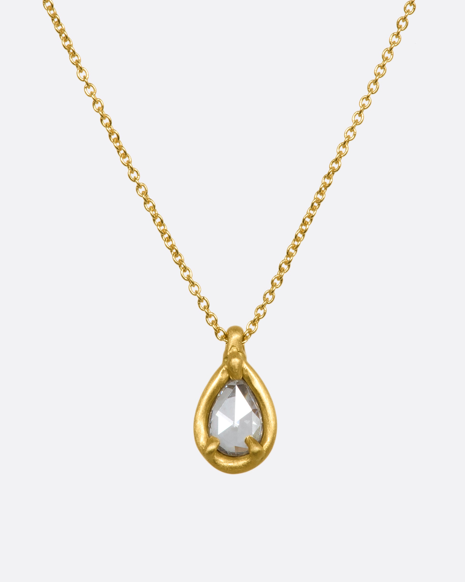 A yellow gold necklace with a rose cut teardrop shaped diamond pendant. Shown from the front.