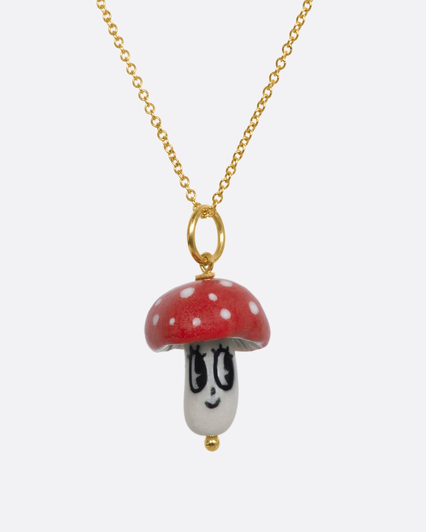 Red mushroom charm on a yellow gold bail. Hanging from a chain.