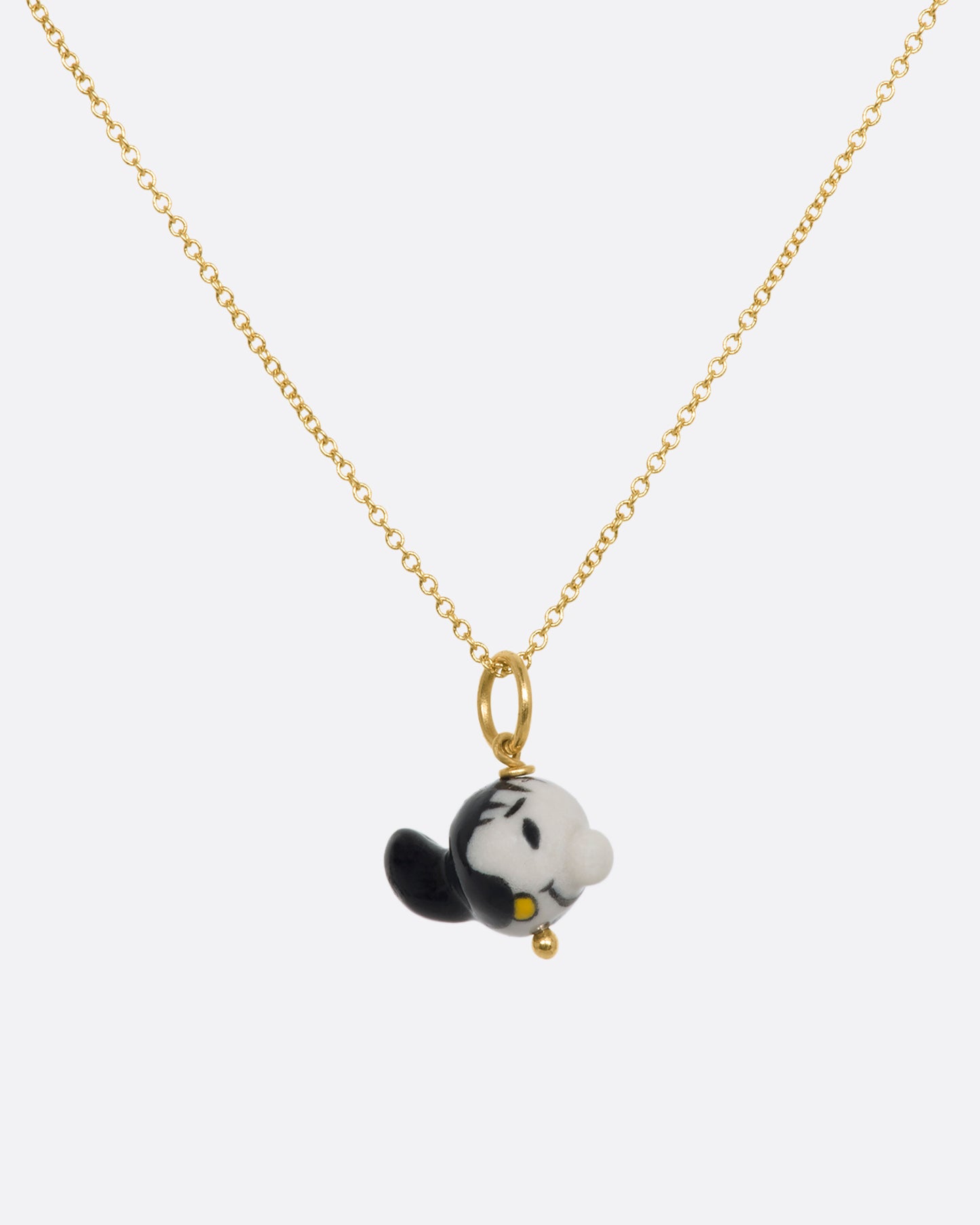 A three dimensional Olive Oyl (from Popeye) charm on a yellow gold bail. Shown on a chain.