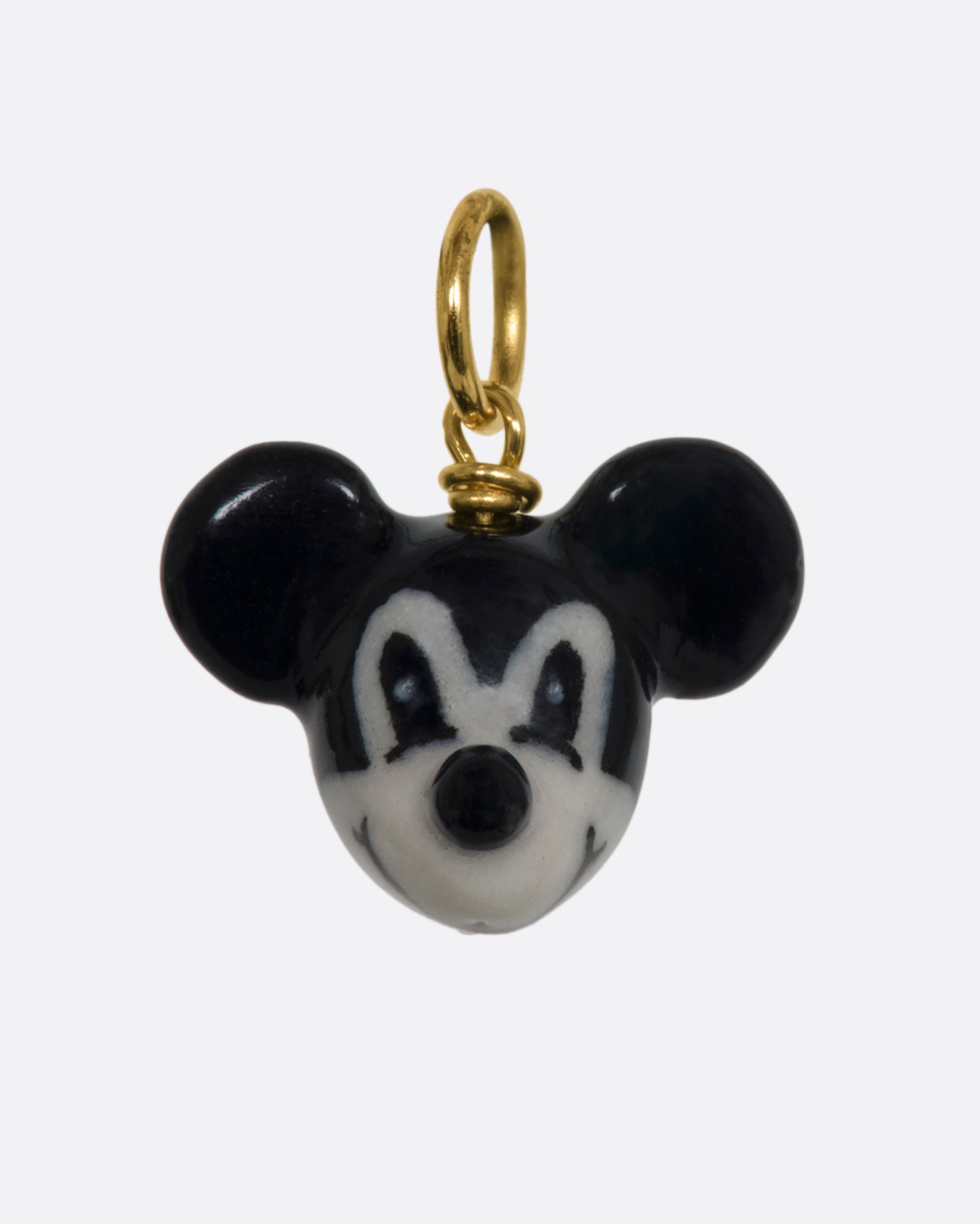 A three dimensional black and white era mickey mouse charm with a yellow gold bail. View from the front.