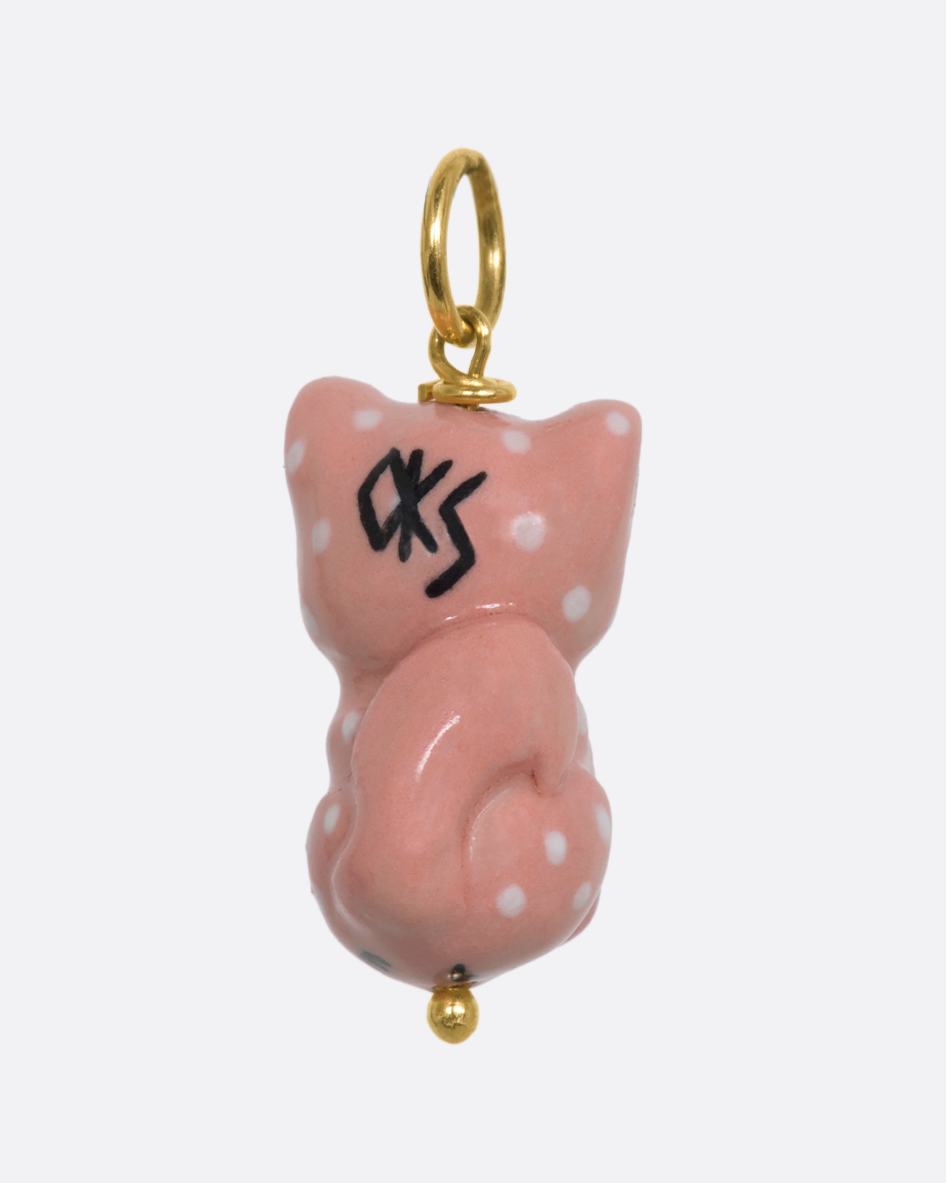 A three dimensional porcelain pink cat charm with white spots. View from the back.