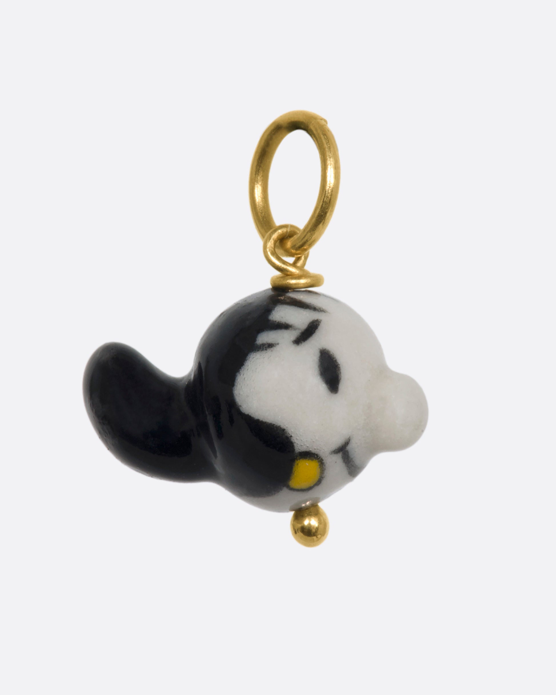 A three dimensional Olive Oyl (from Popeye) charm on a yellow gold bail. View from the side.