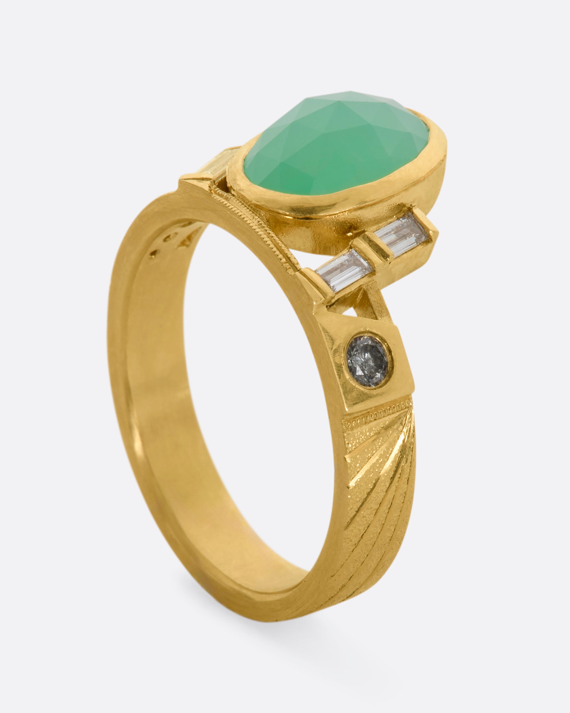 A yellow gold wide band ring with an oval chrysoprase, stacked baguette and round diamonds. View standing up.