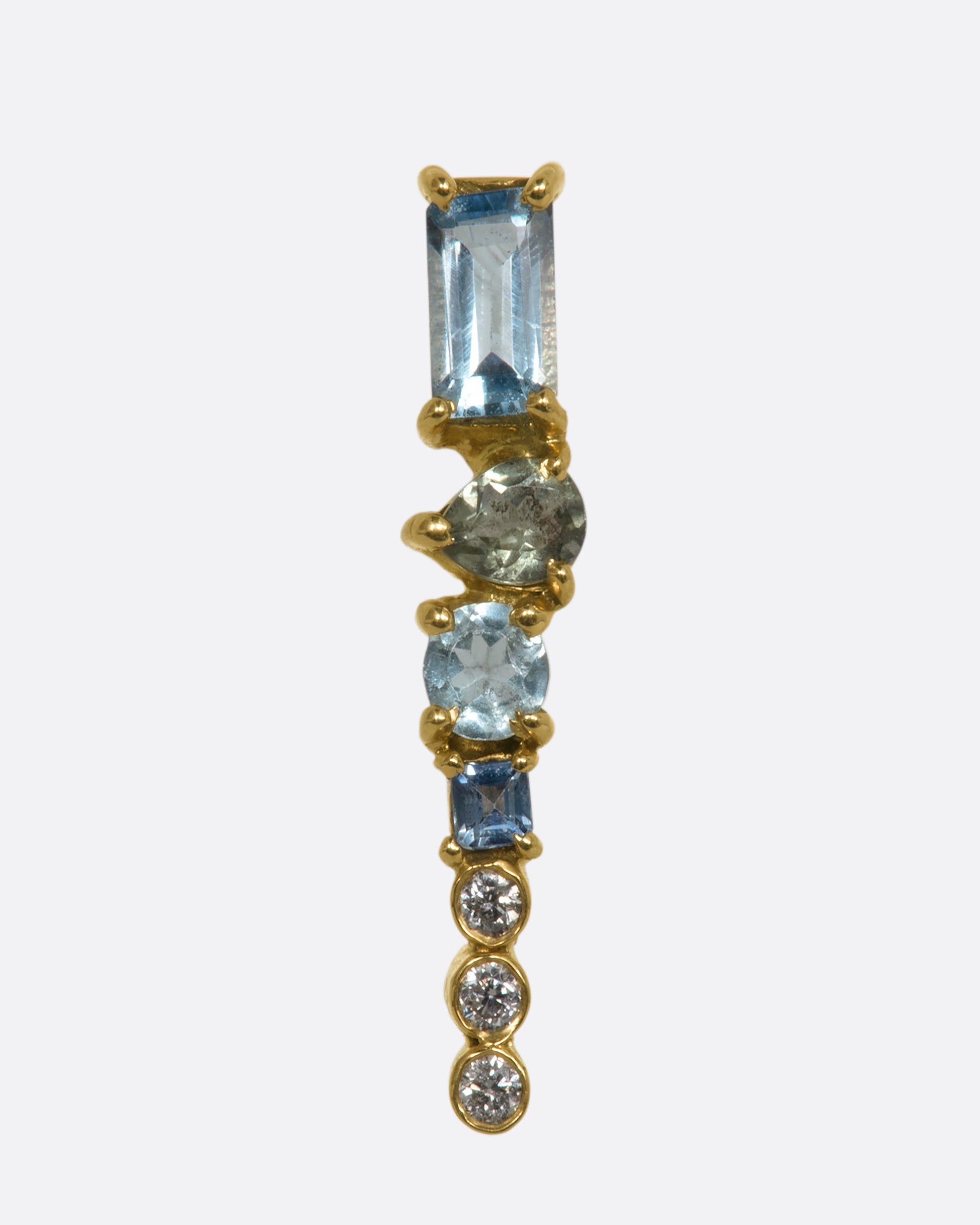 A yellow gold stud earring with a mosaic of aquamarine, tanzanite, apatite and diamonds. Shown from the front.