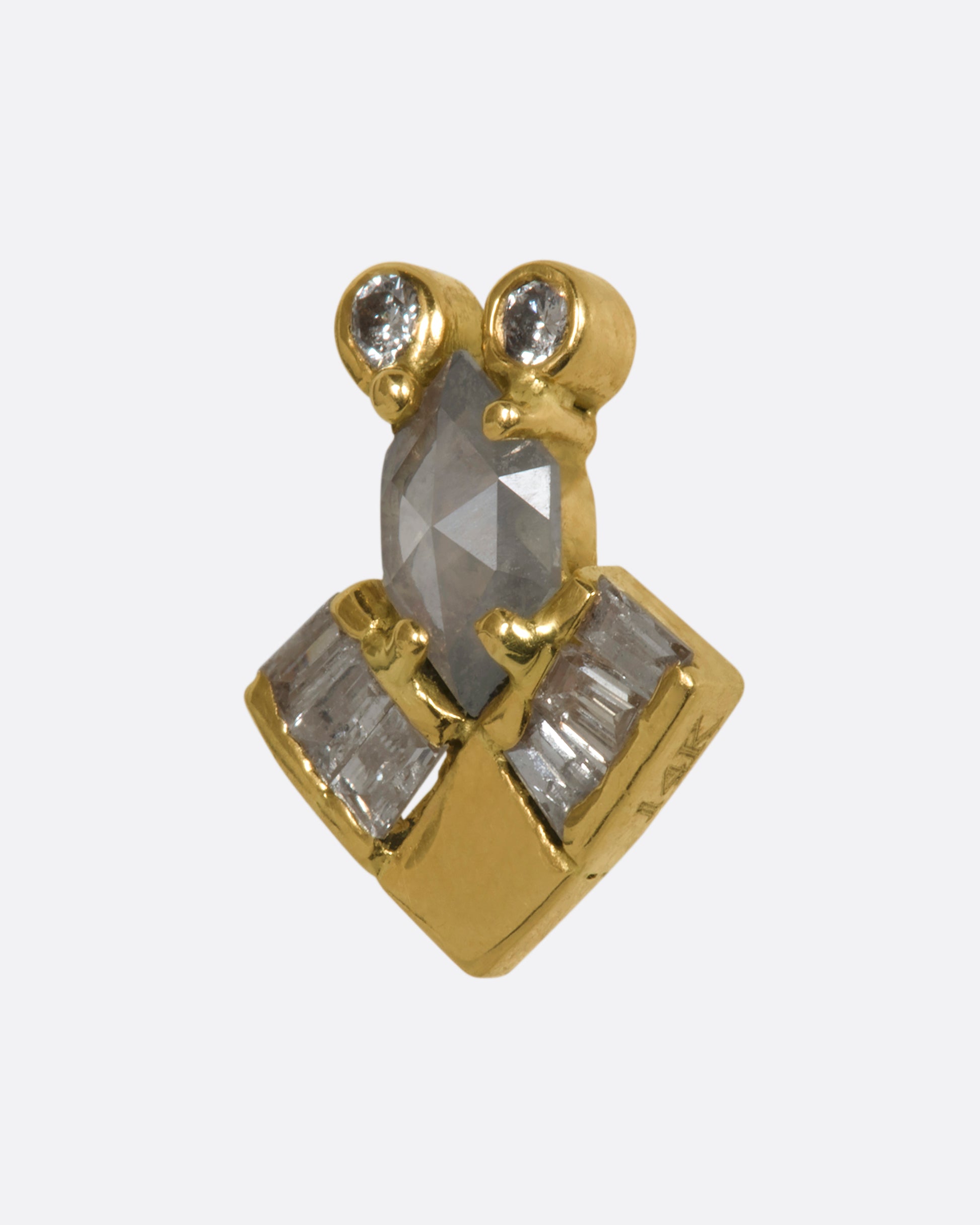 An abstract yellow gold stud earring with salt and pepper rose cut round and baguette diamonds. View from the side.