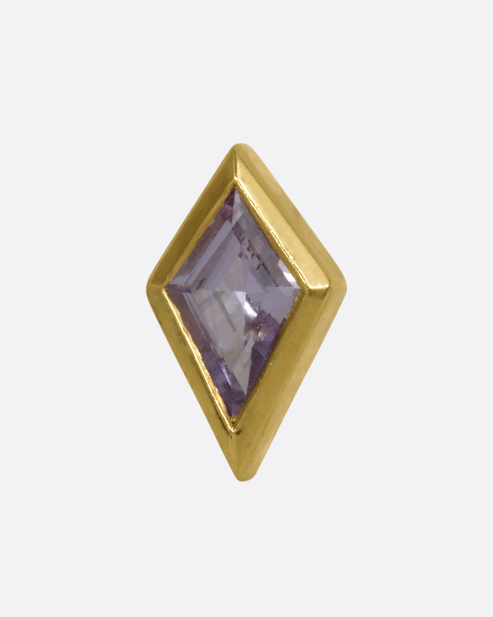 A yellow gold kite shaped stud with a bezel set sapphire.