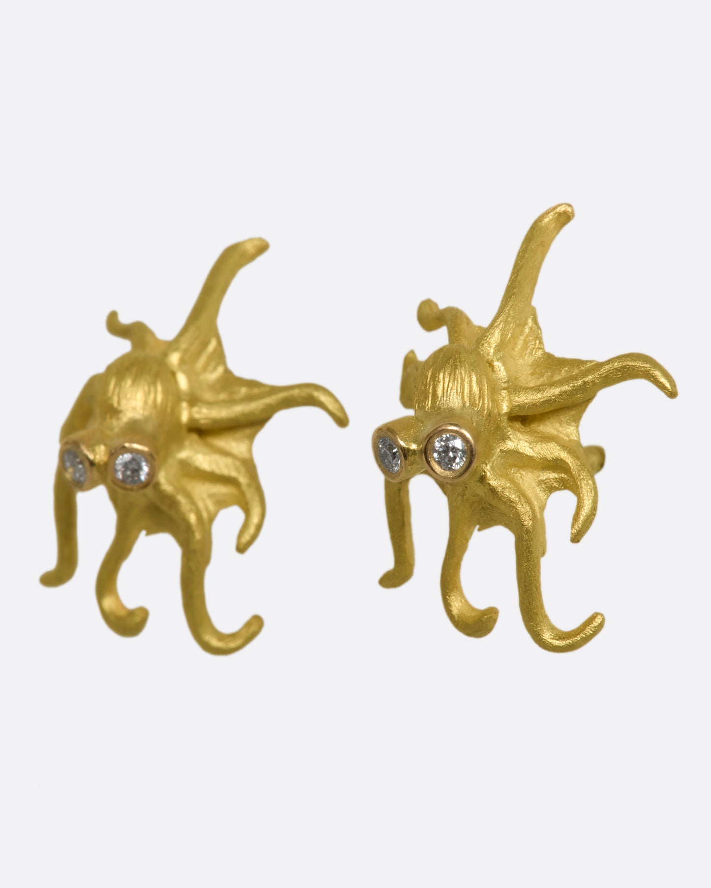 Yellow gold octopus earrings with diamond eyes. View from the side.